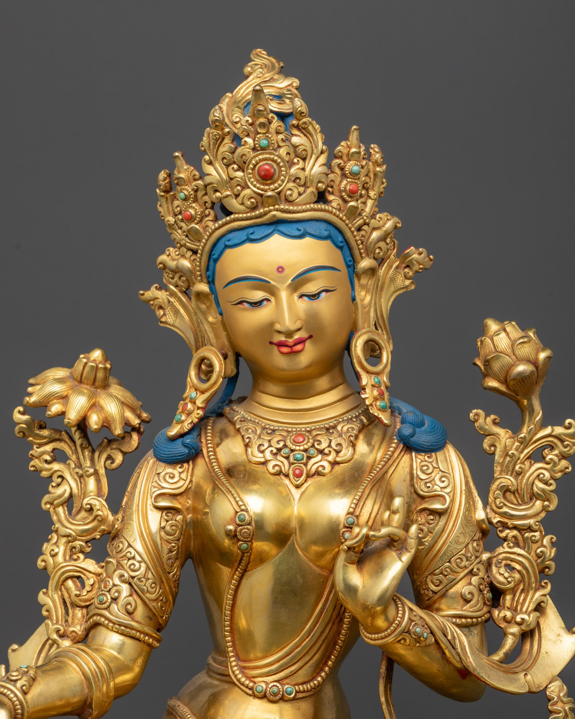 Close up of Green Tara holding Utpala flower with five-jeweled crown detail

