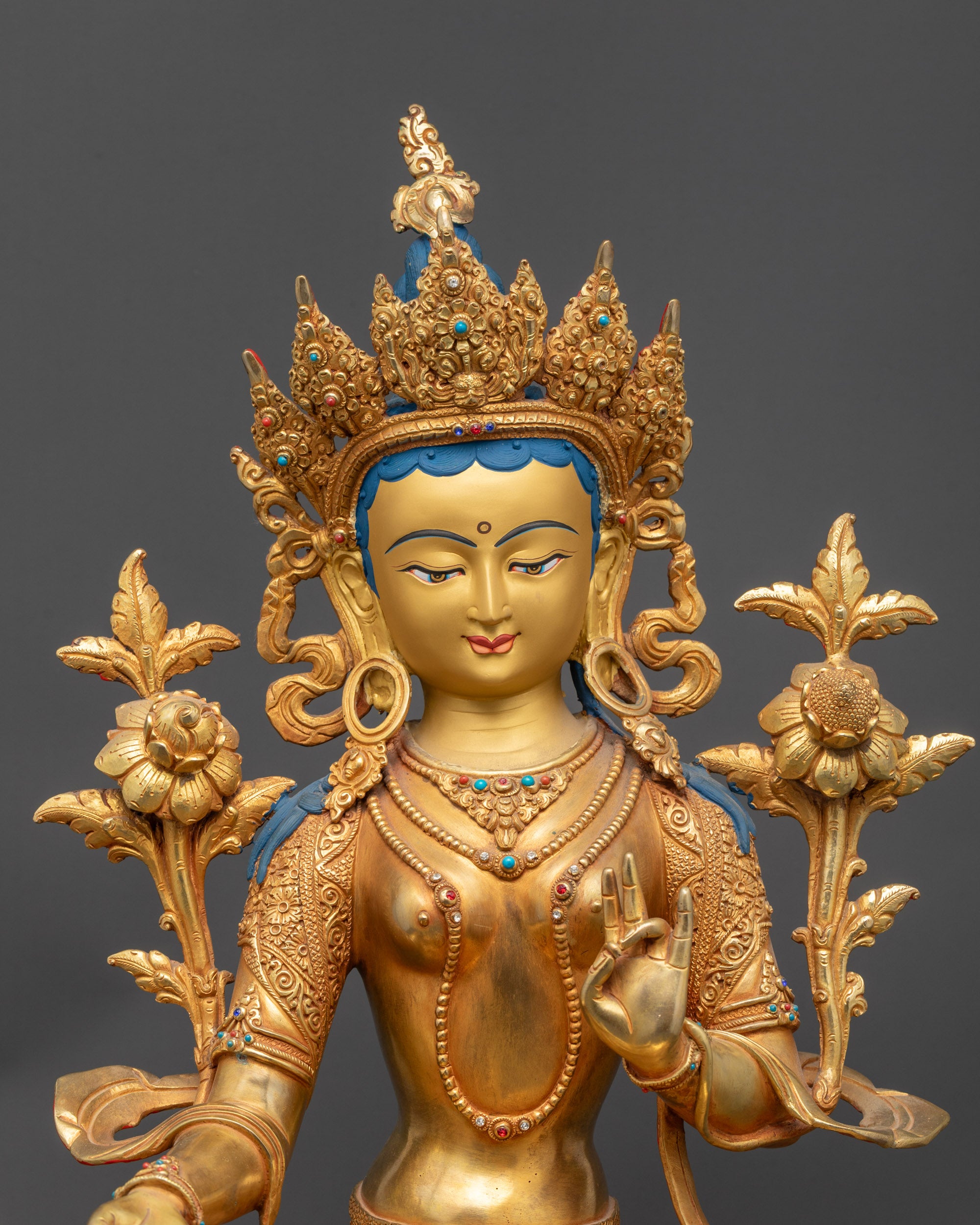 Close up of Green Tara statue showing five-jeweled crown and Utpala flower
