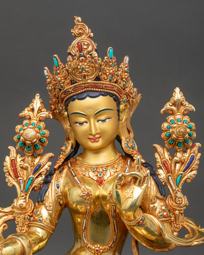 Close up of Green Tara statue showing hand mudra and gold gilded details