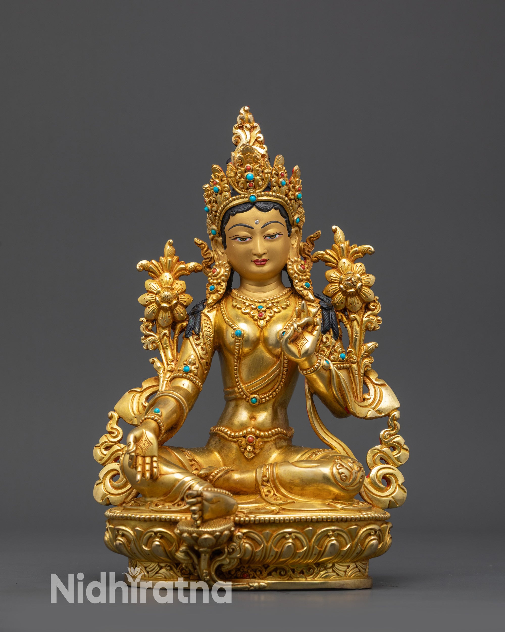 Close up of Green Tara with utpala flower, serene expression, and jeweled crown