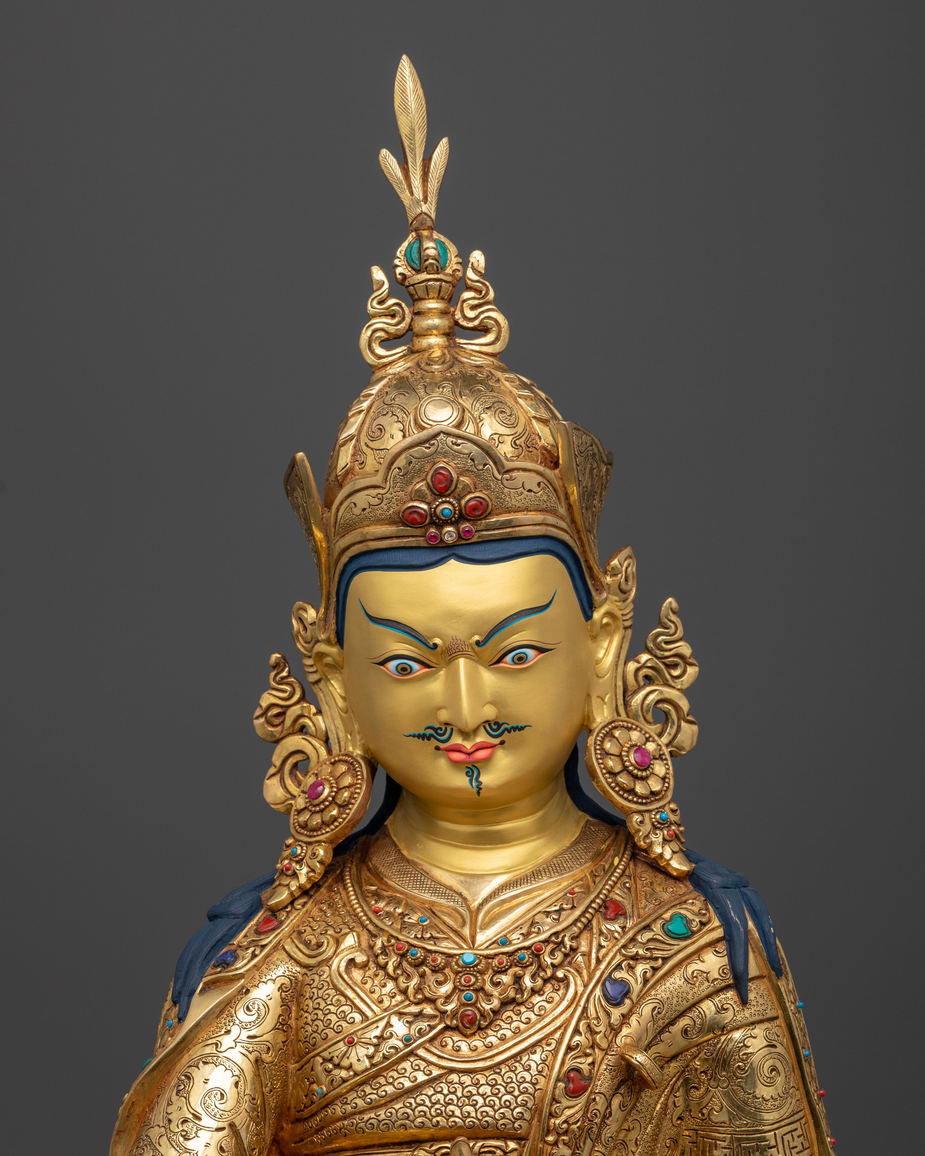 Close up of Guru Pema Jungne gold-painted face with lotus hat and semi-precious stones, hand-carved Newari Himalayan statue
