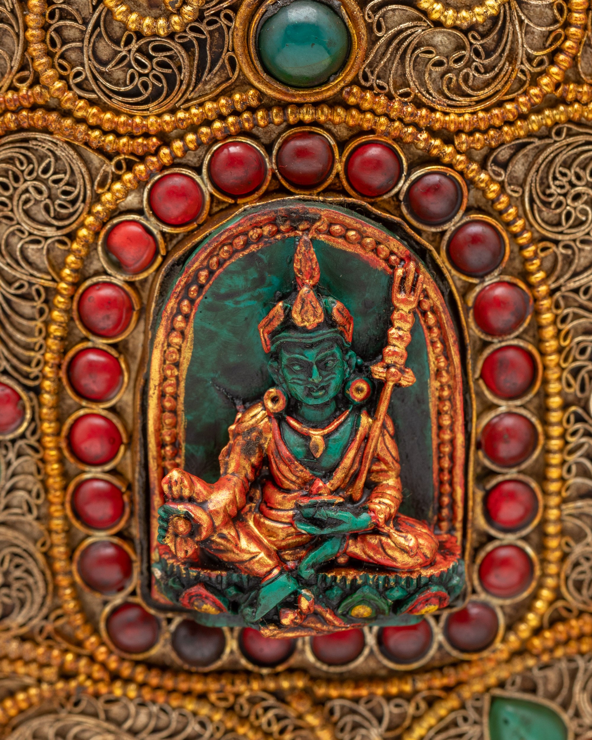 Close up of Guru Rinpoche carving on Tibetan ritual rice pot