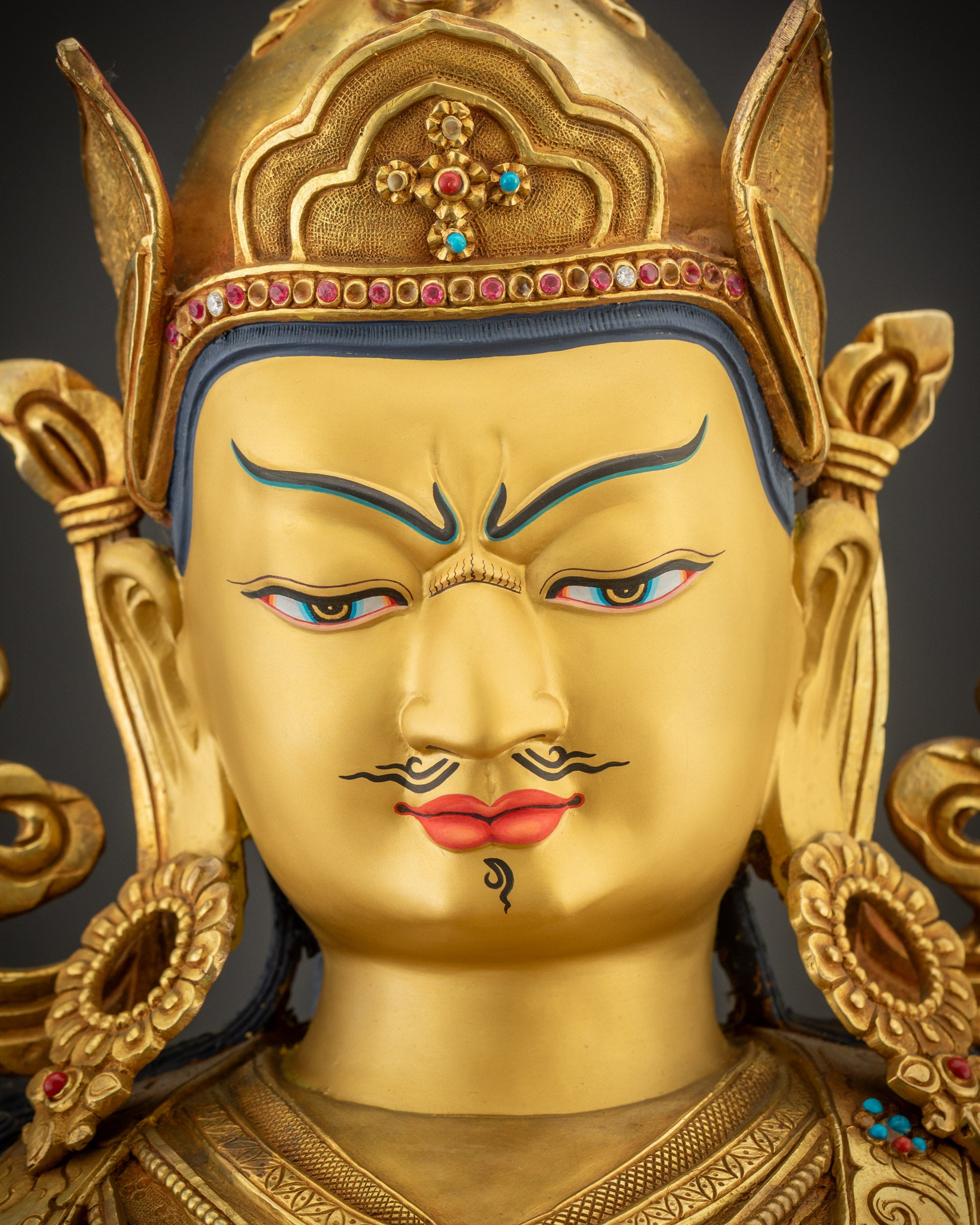 Close up of Guru Rinpoche face showing serene yet wrathful expression
