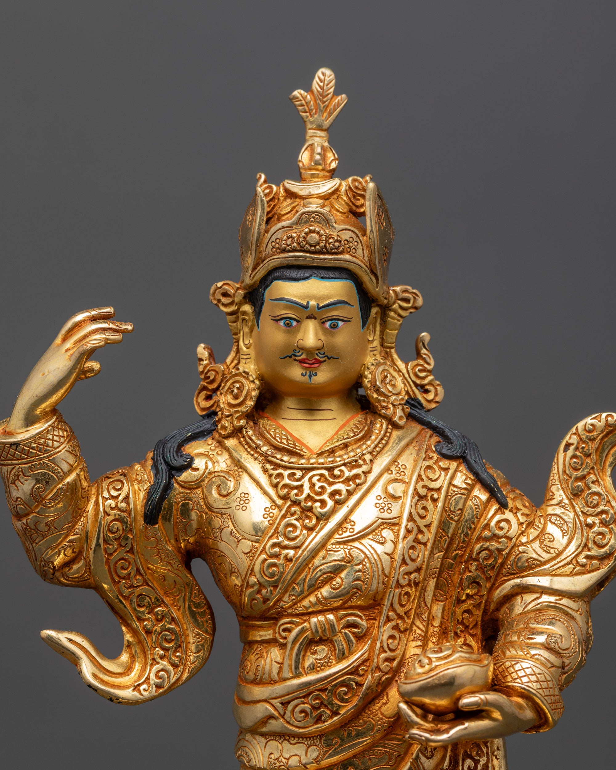 Close up of Guru Rinpoche statue showing lotus crown, jewelry, and detailed carvings

