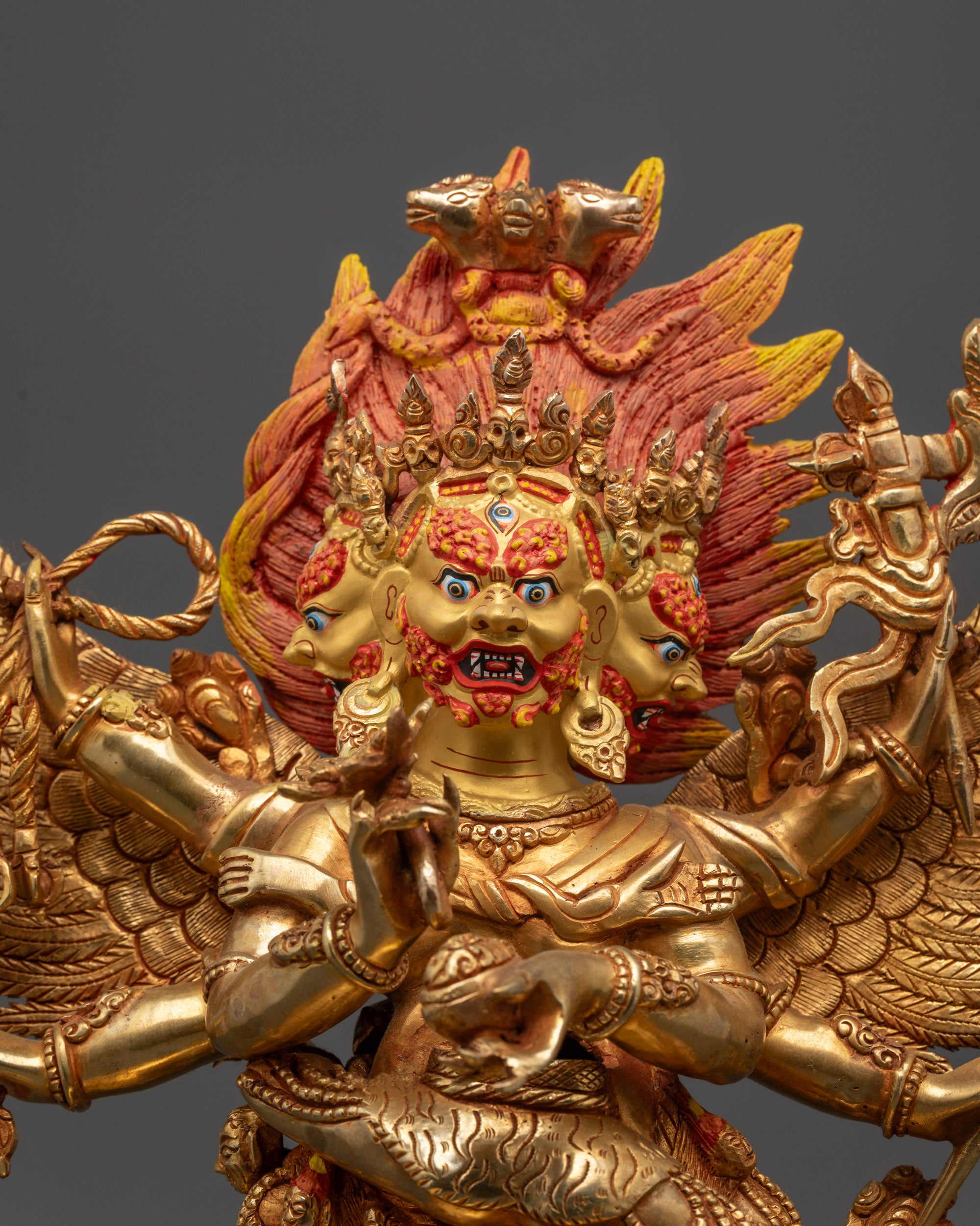 Close up of Hayagriva Statue showing Gold-gilded three fierce faces and intricate Dhoti robe details
