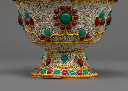 Close up of Himalayan carved Water Offering Bowl showing ruby and emerald details
