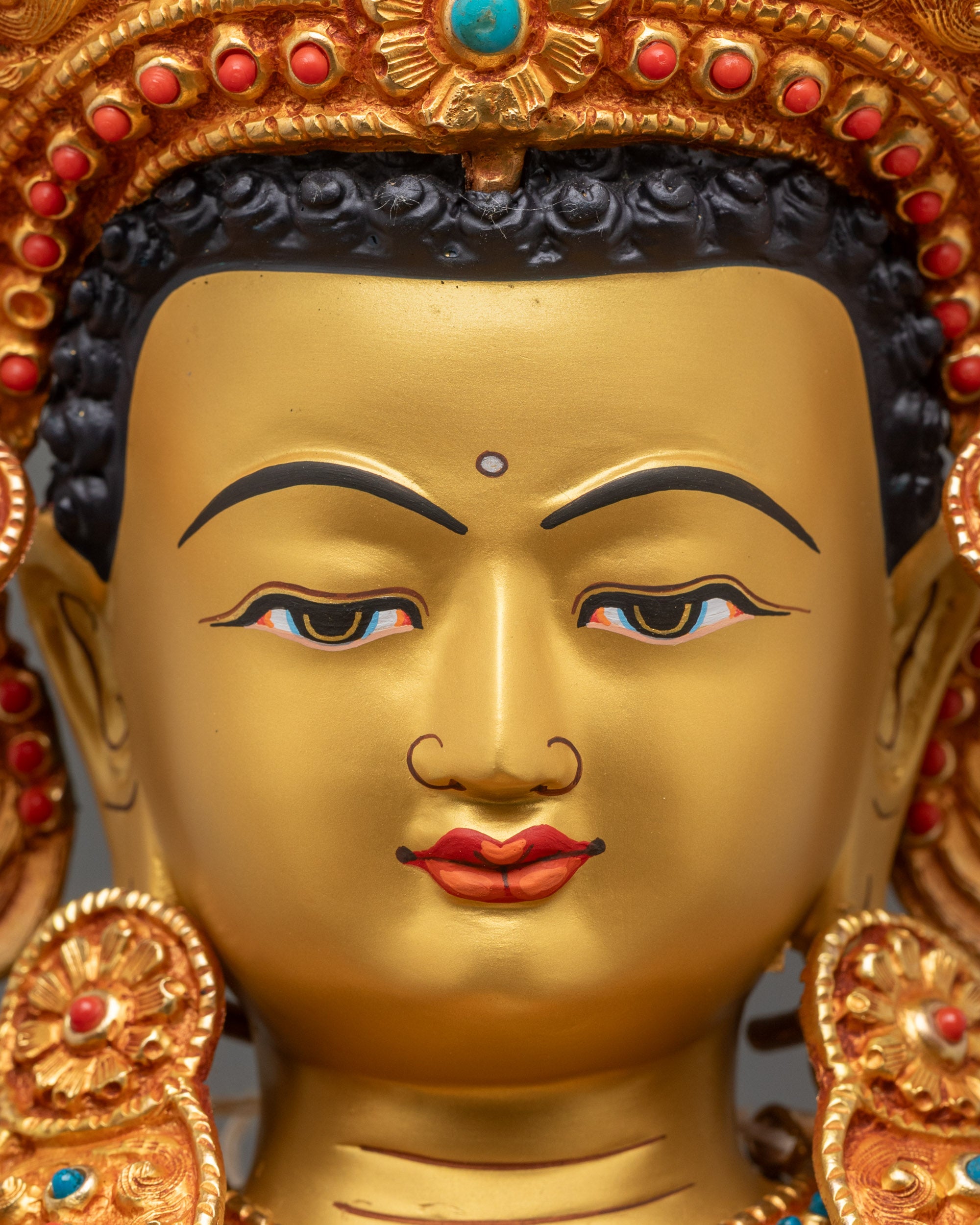 Close up of Jowo Shakyamuni Buddha gold-gilded face with serene expression, sacred artwork