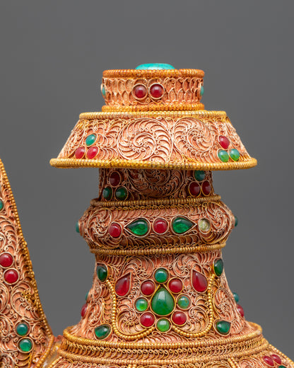 Close up of Karuwa Bhumba showing intricate gold-plated filigree and aligned emeralds and rubies
