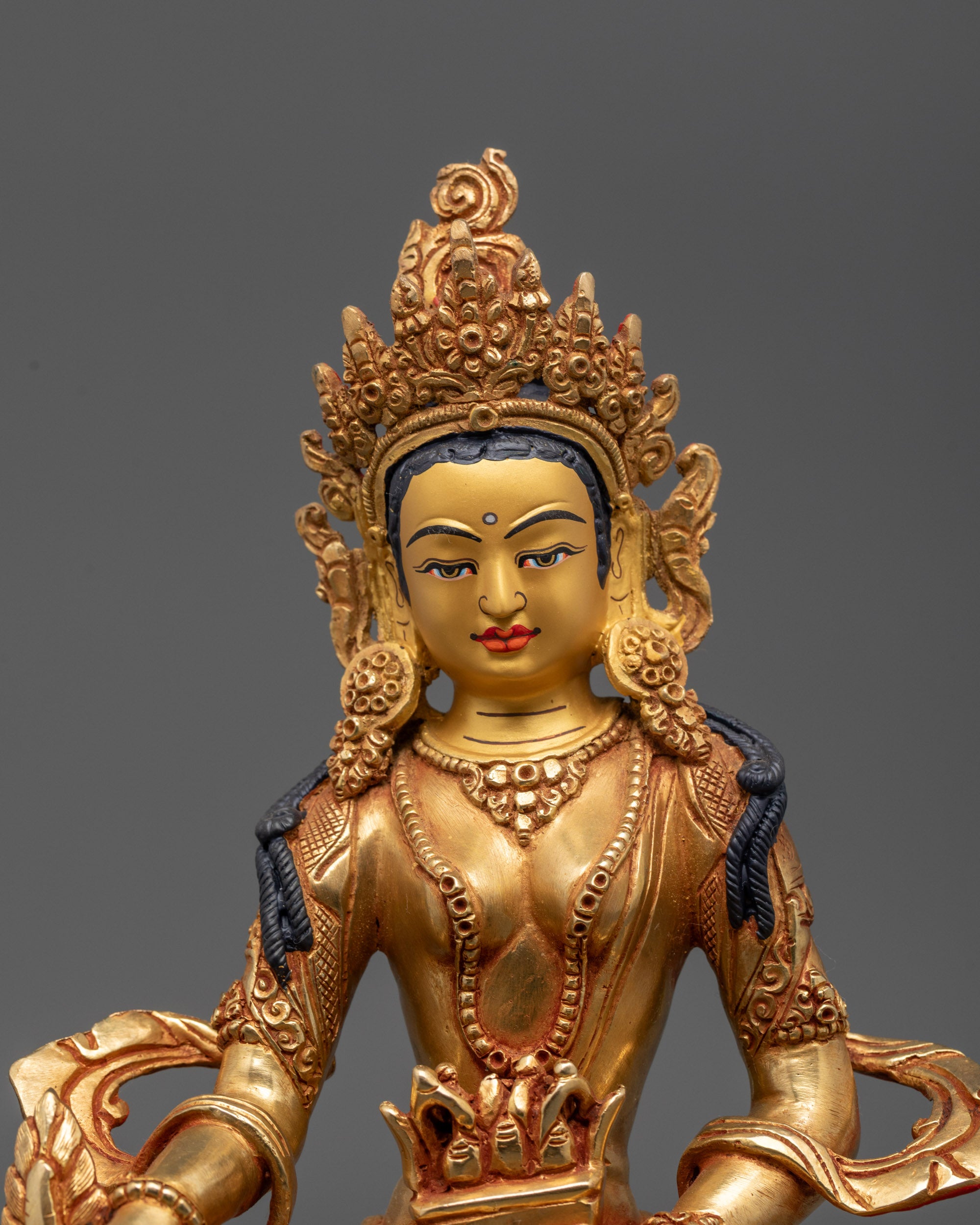 Close up of Ksitigarbha’s crown, Chintamani, feathers, and detailed carved robes