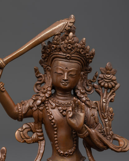Close up of Manjushri Sculpture showing Abhaya mudra and intricate oxidized copper details