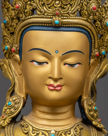 Close up of Manjushri Statue showing gold-gilded face and detailed flowing robes
