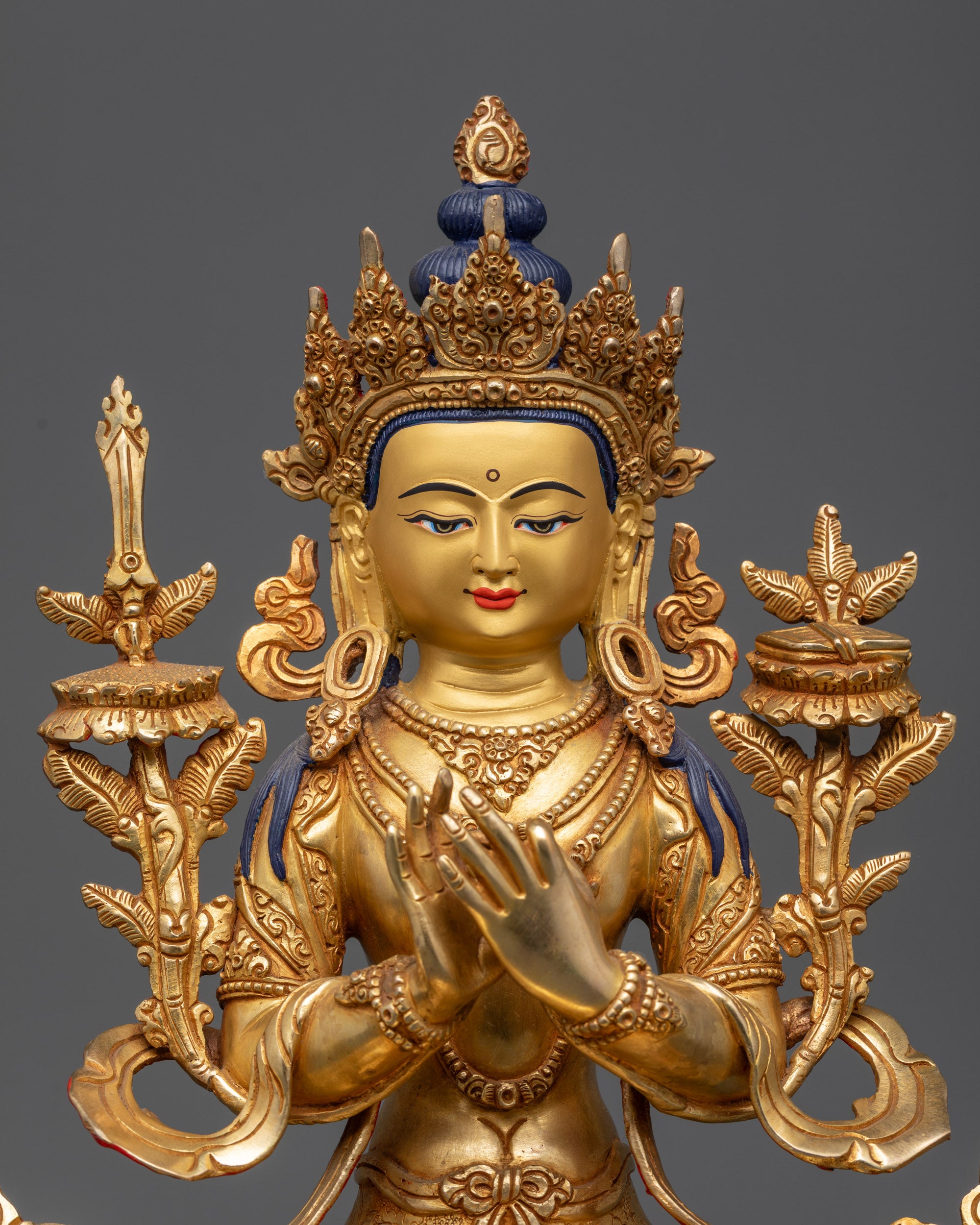 Close up of Manjushri's gold-gilded face and intricate patterned robes