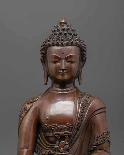 Close up of Medicine Buddha face showing oxidized copper finish and serene healing expression