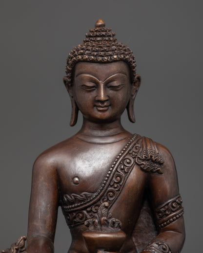 Close up of Medicine Buddha statue showing intricate details and earthy oxidized copper finish
