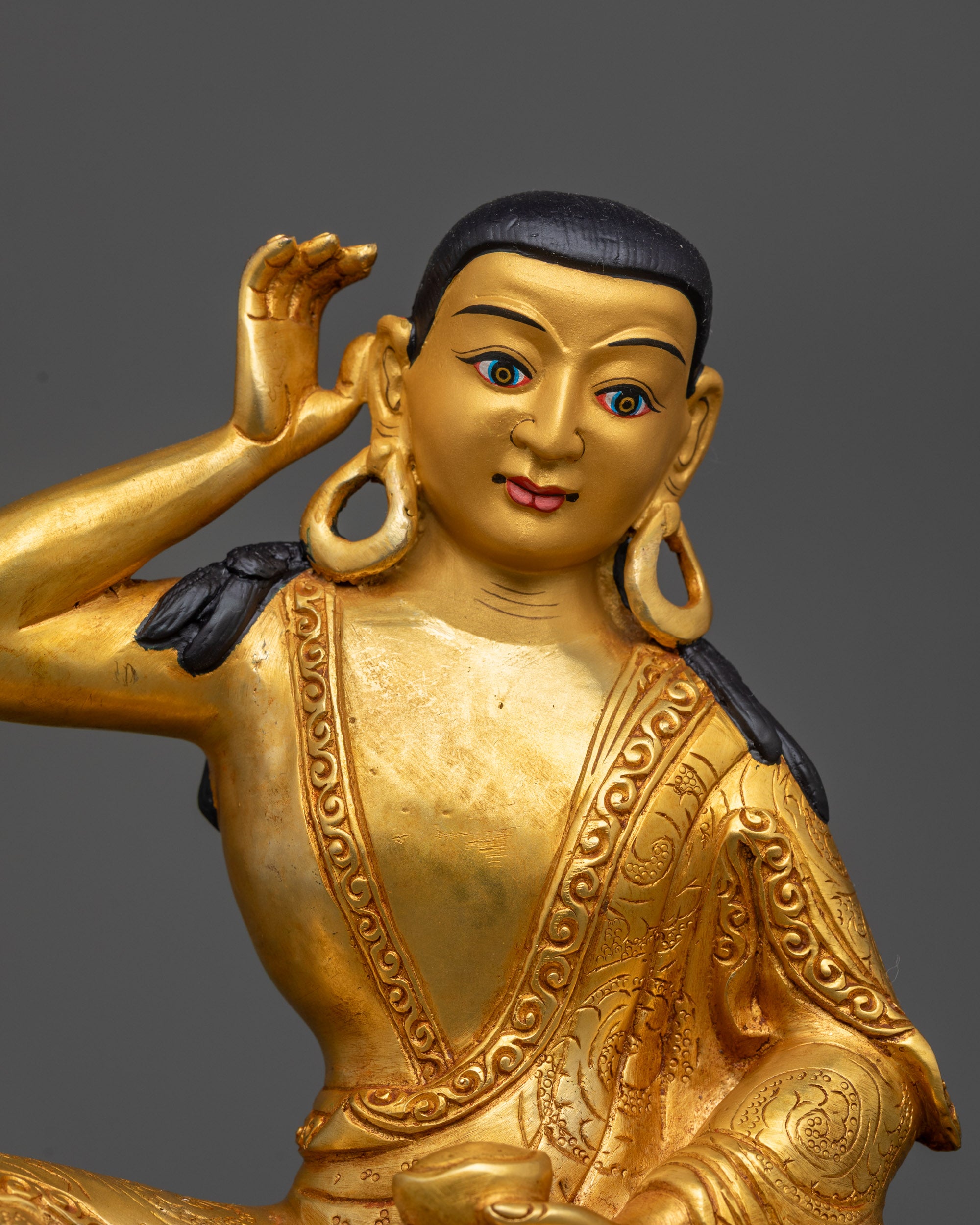 Close up of Milarepa Statue showing 24K gold-gilded face and detailed begging bowl