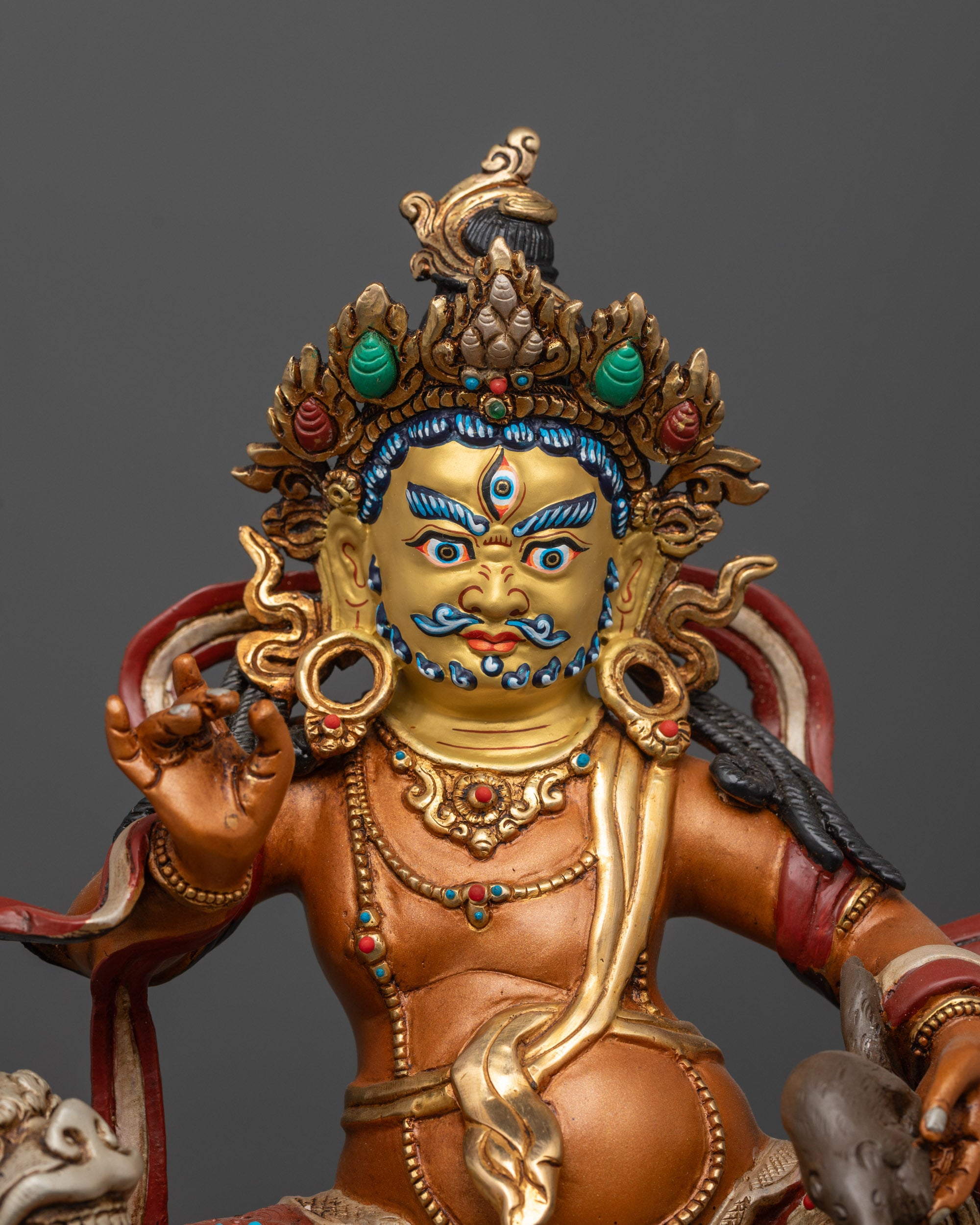 Close up of Namtoshe Sculpture showing gold-gilded face and intricate semi-precious stones