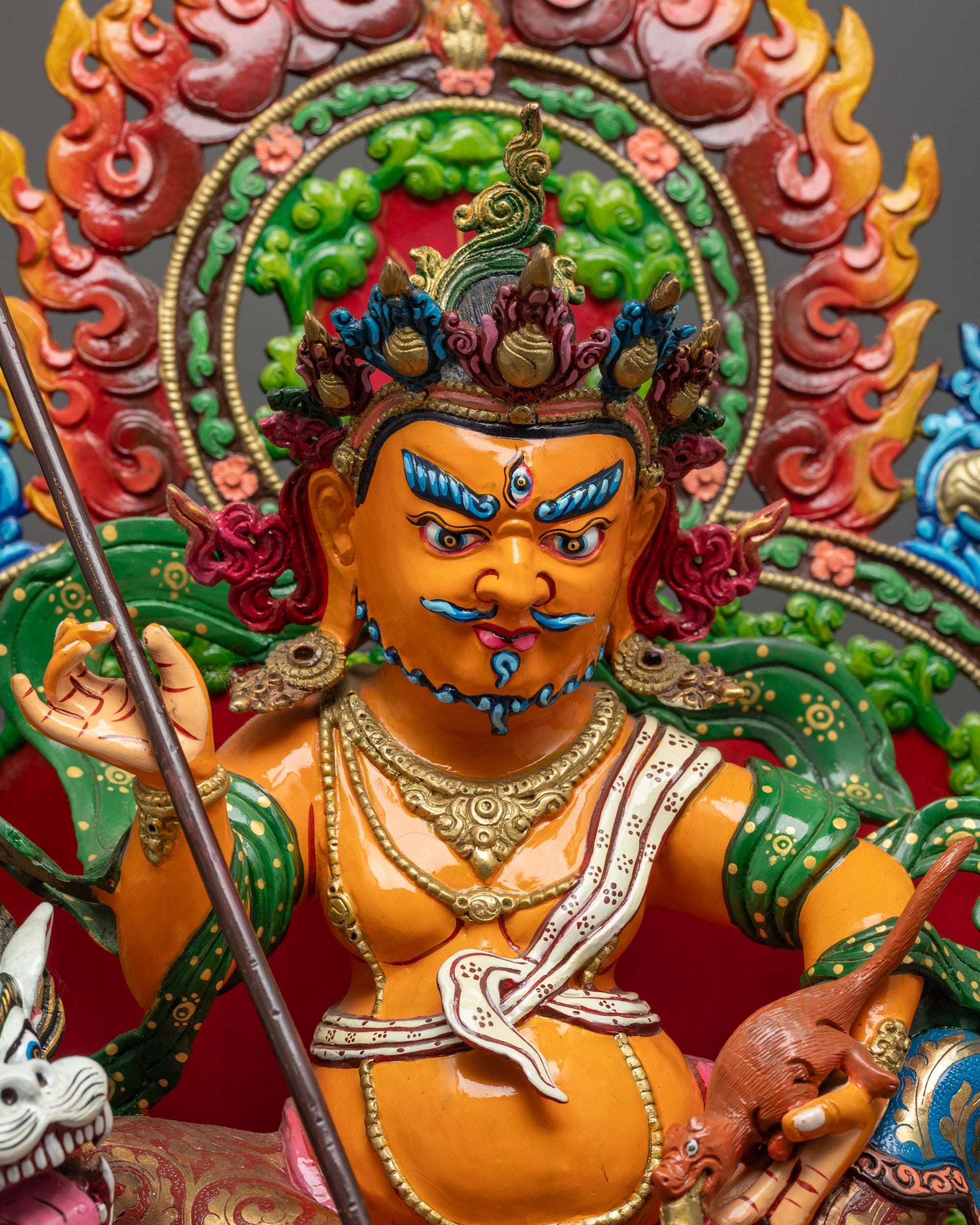 Close up of Namtoshe Statue showing intricate gold detailing and vibrant orange body