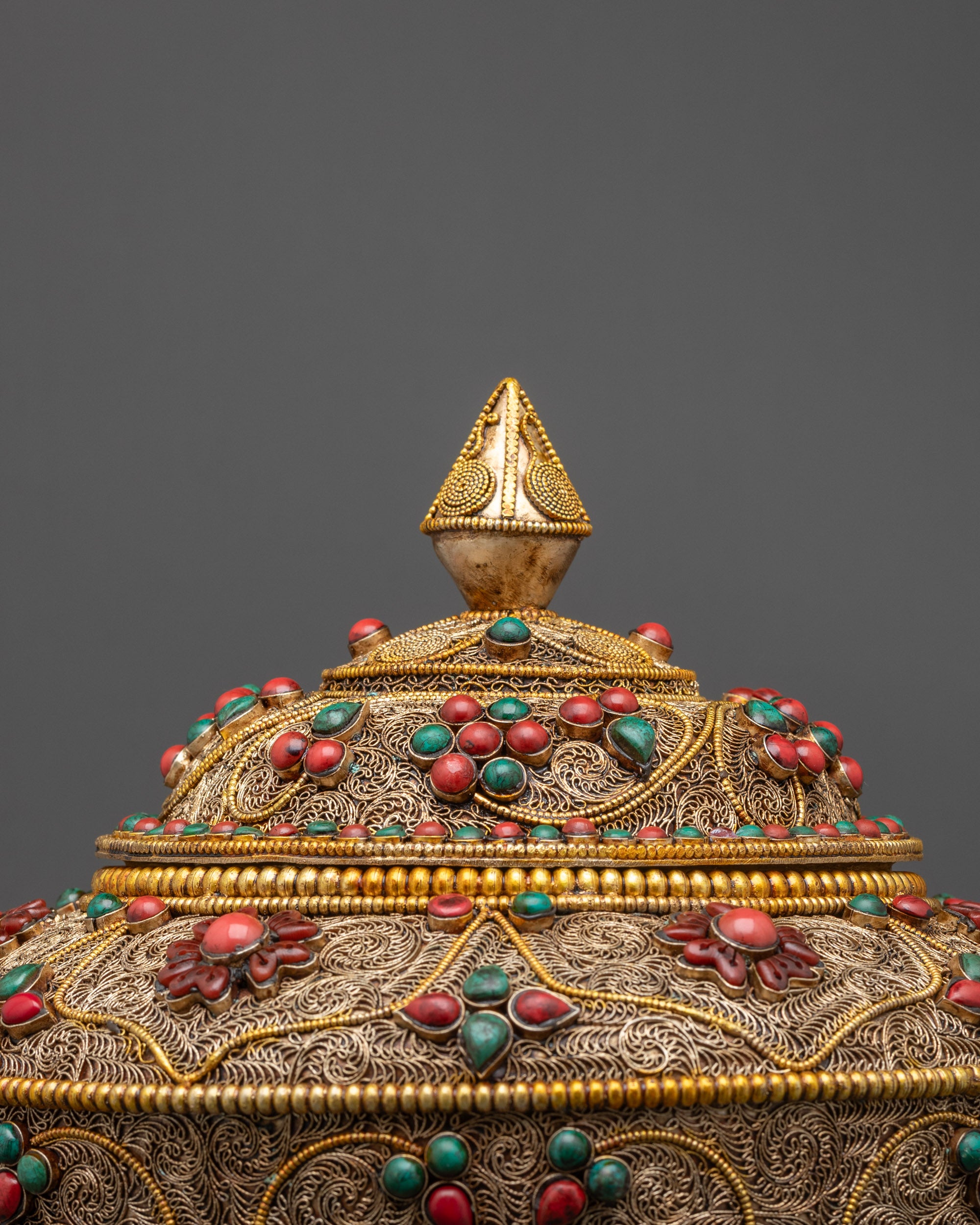 Close up of Neshi Rice Pot lid showing pointed gold-plated top and intricate filigree work