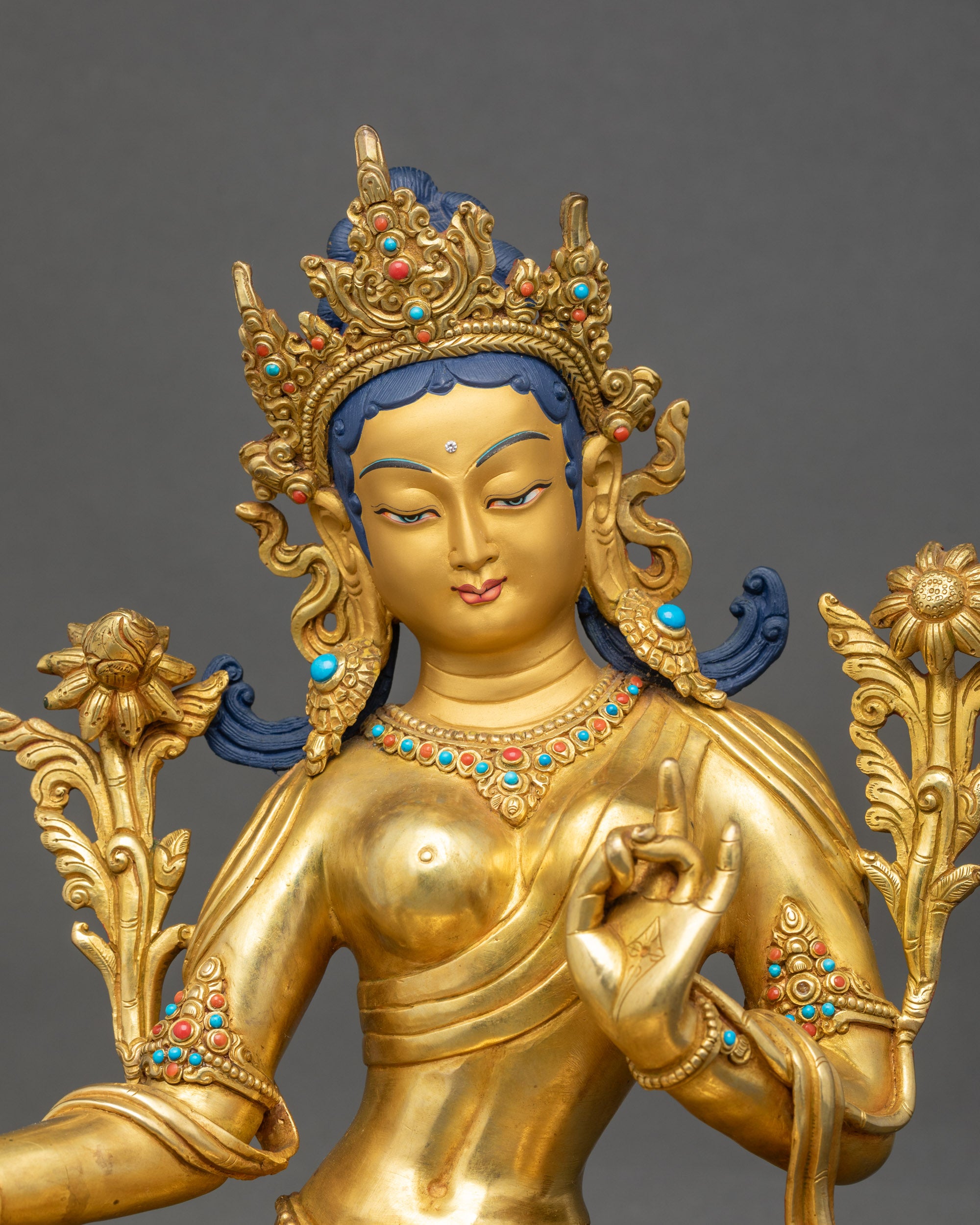 Close up of Premium Green Tara Statue with gold-gilded face and lotus base