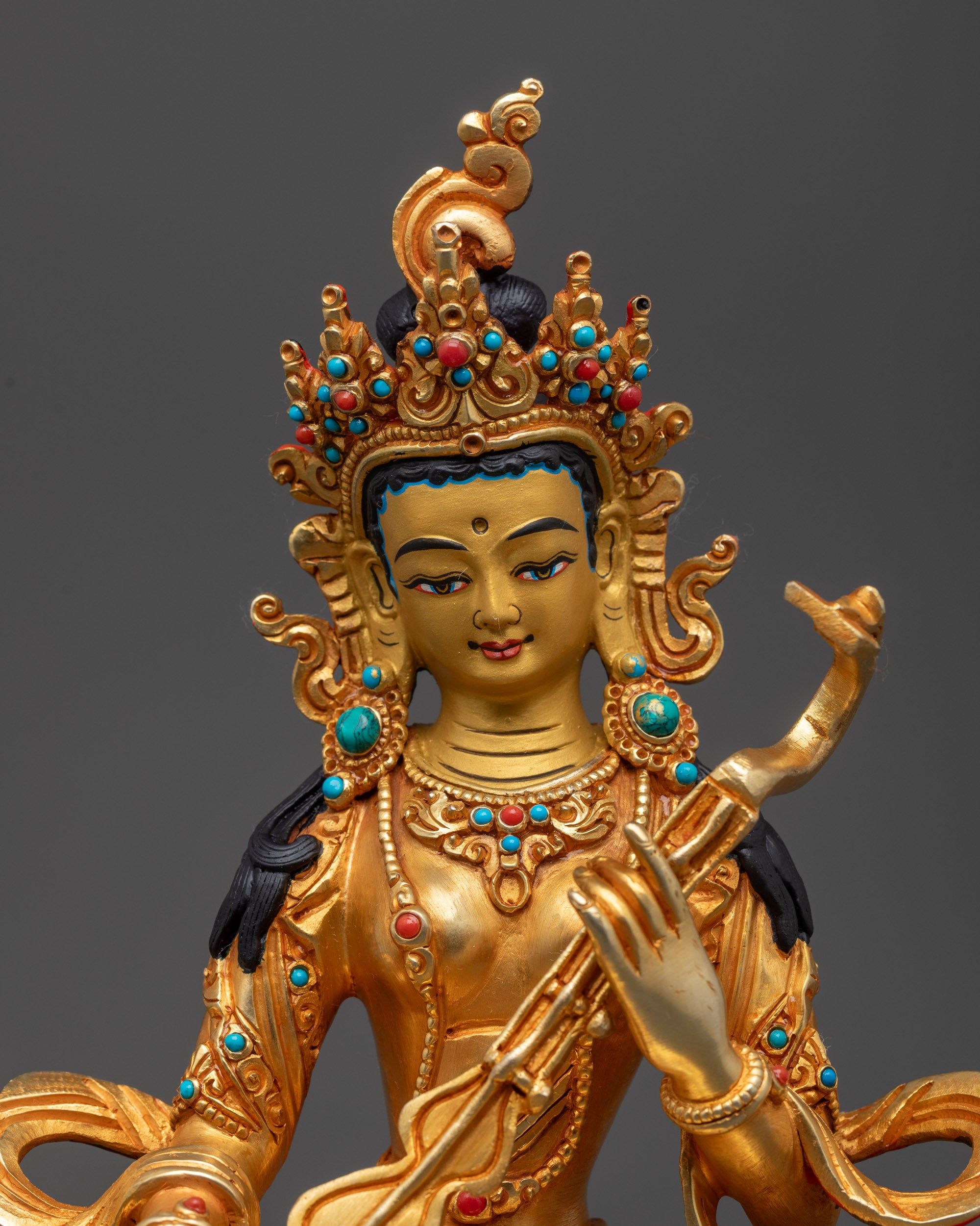 Close up of Saraswati Statue intricate carvings holding veena gold fire-gilded body