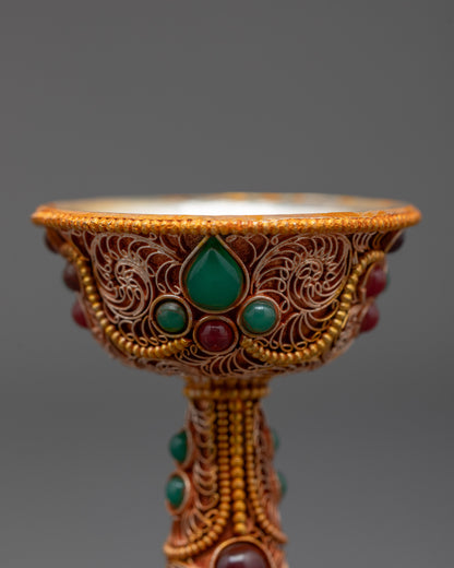 Close up of Serkyem Offering Bowl showing emerald and ruby gemstones and intricate carvings
