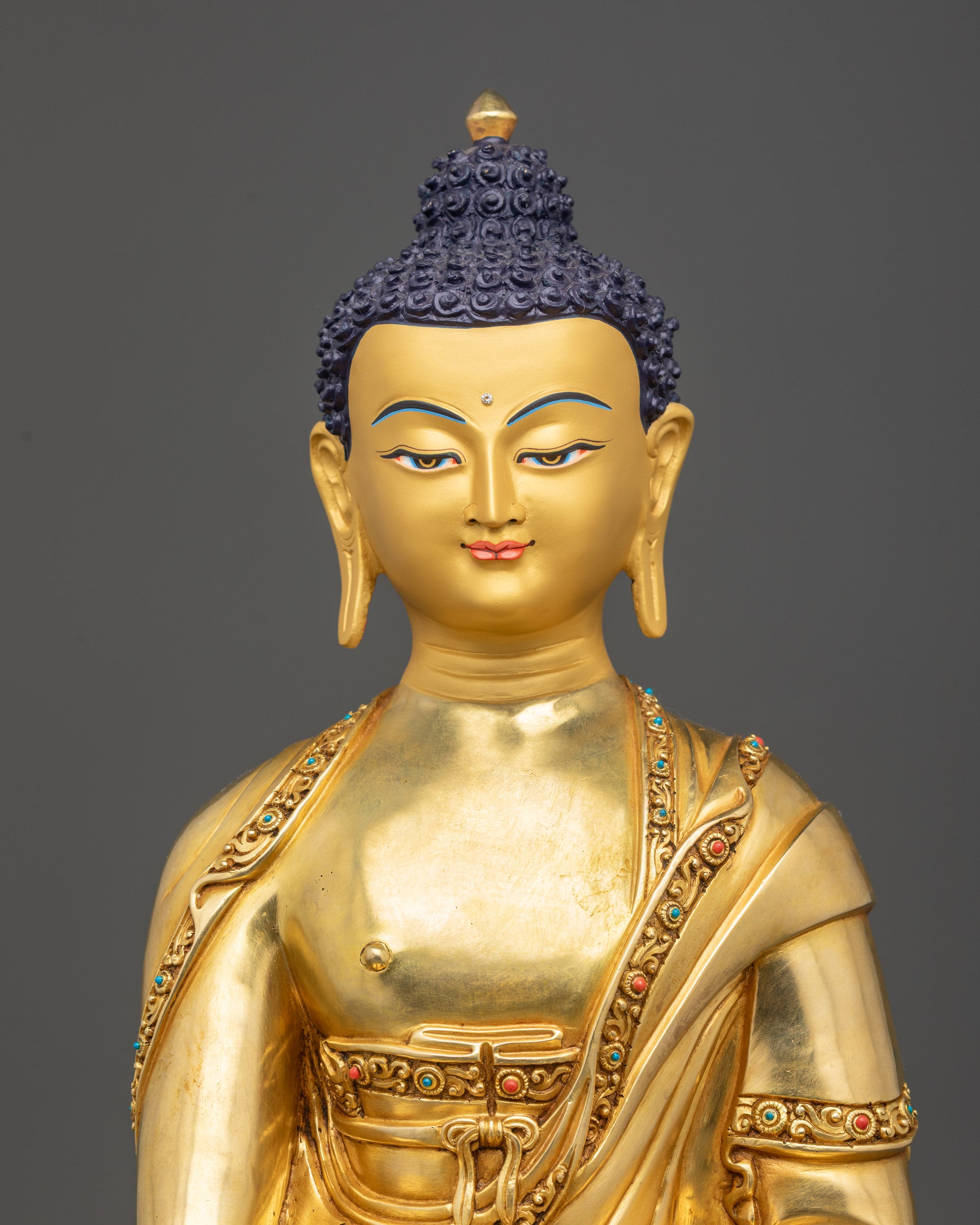 Close up of Shaka Buddha face with radiant gold gilding and serene expression