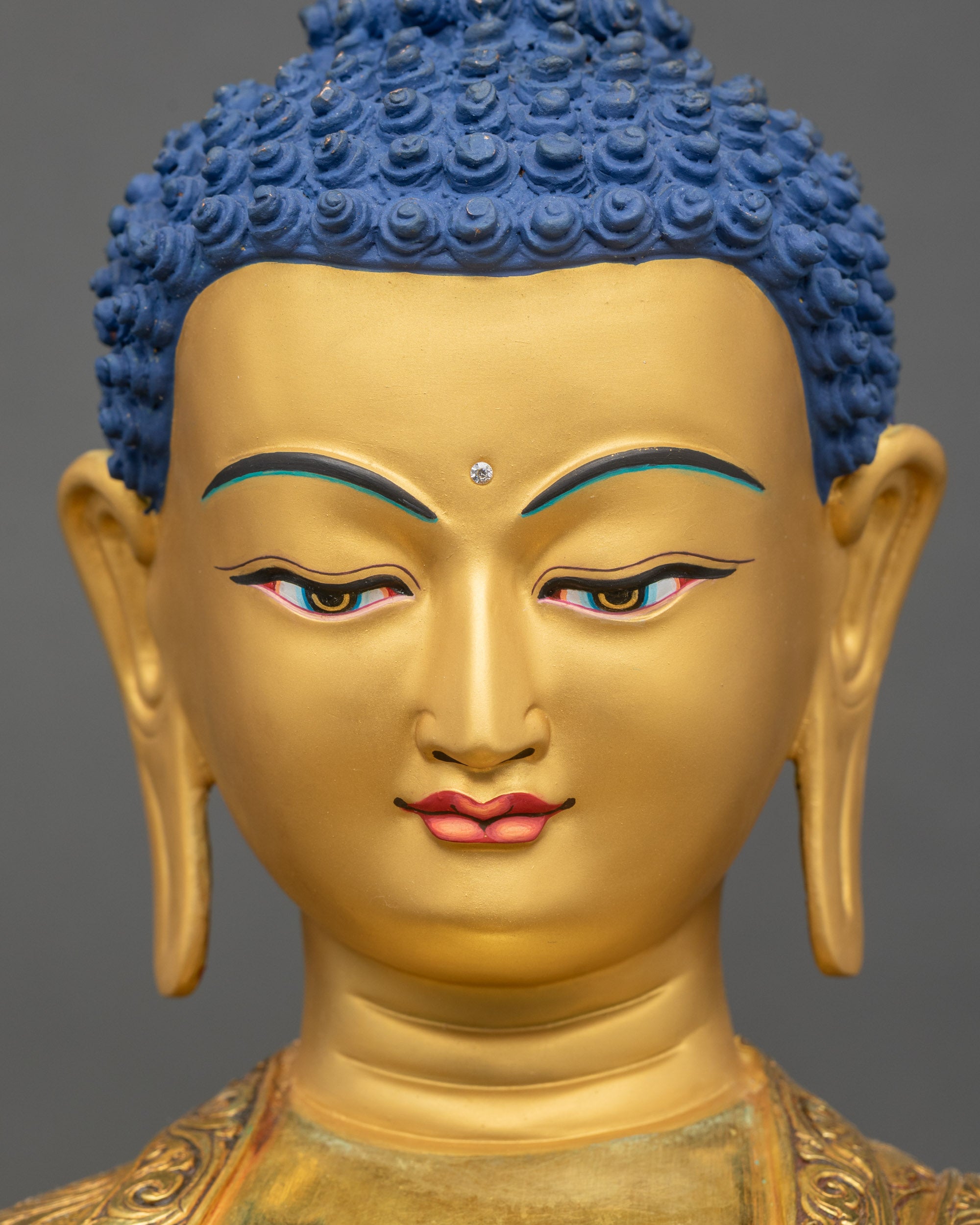 Close up of Shakyamuni Buddha gold-gilded face with tranquil expression