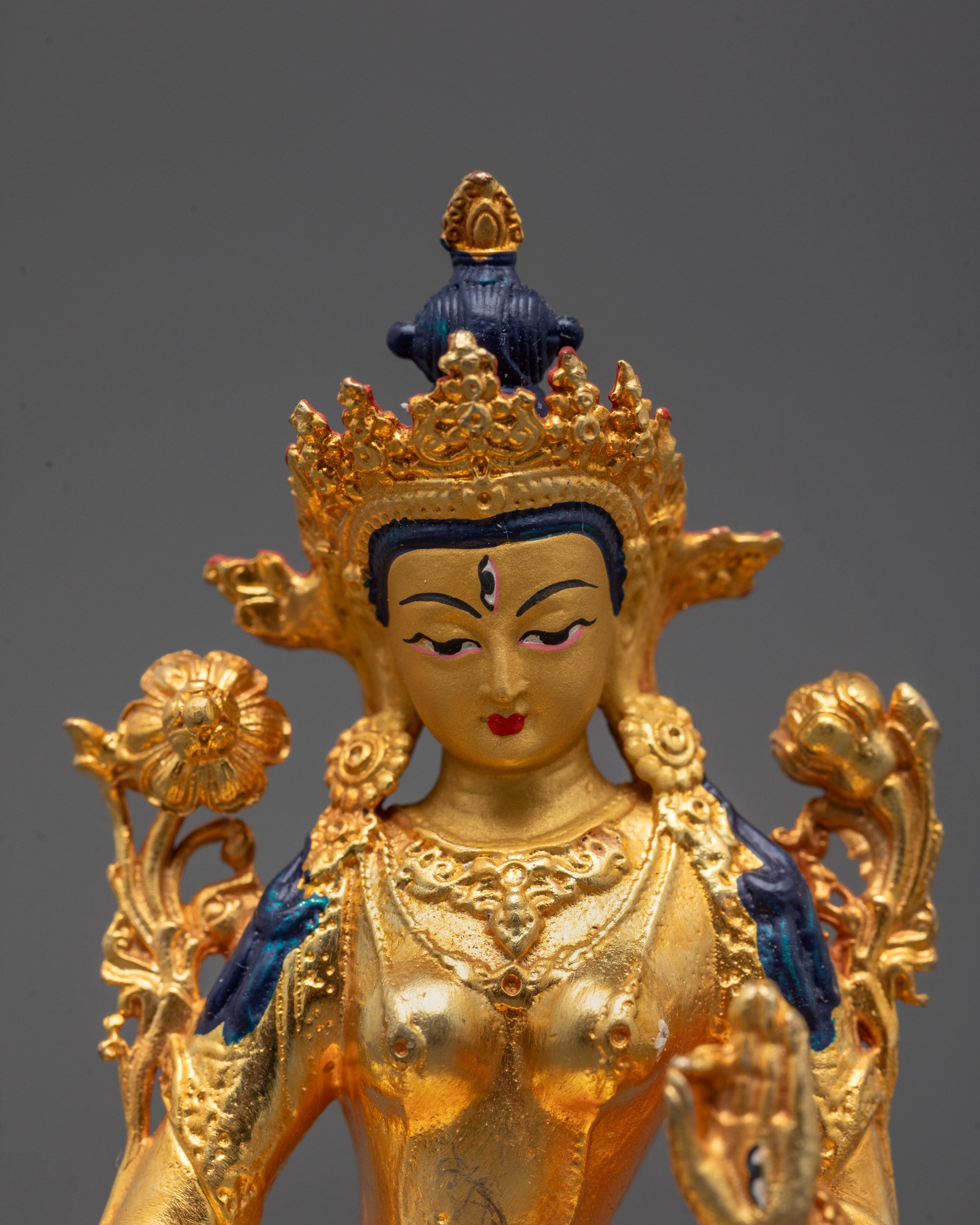 Close up of Sita Tara statue’s seven all-seeing eyes and detailed jewelry with utpala flower