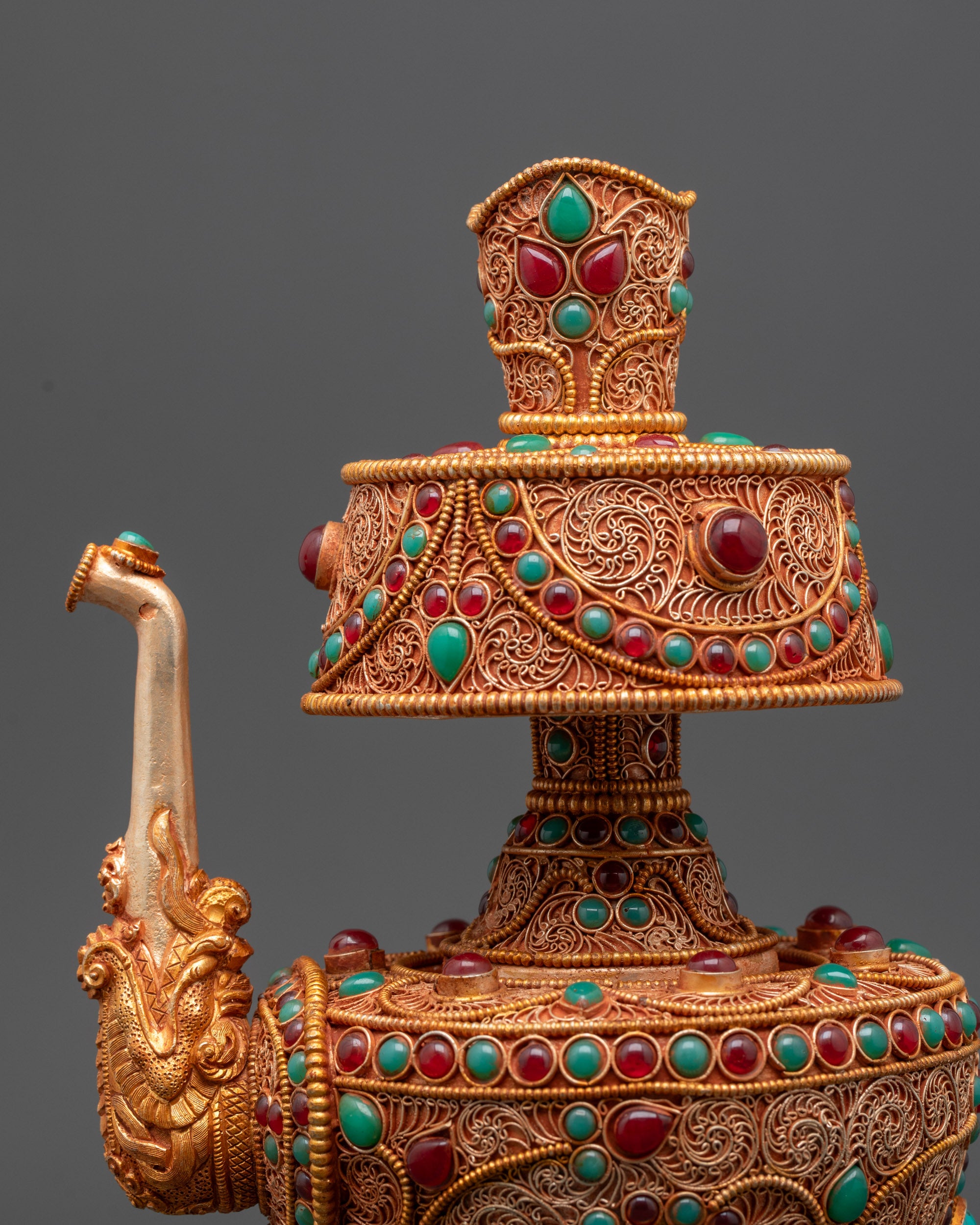 Close up of Tibetan Bhumba gold-plated filigree and semi-precious stones on copper body
