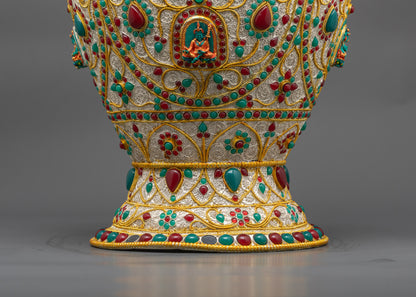 Close up of Tibetan rice pot showing Dzambhala carving with ruby turquoise emerald gems