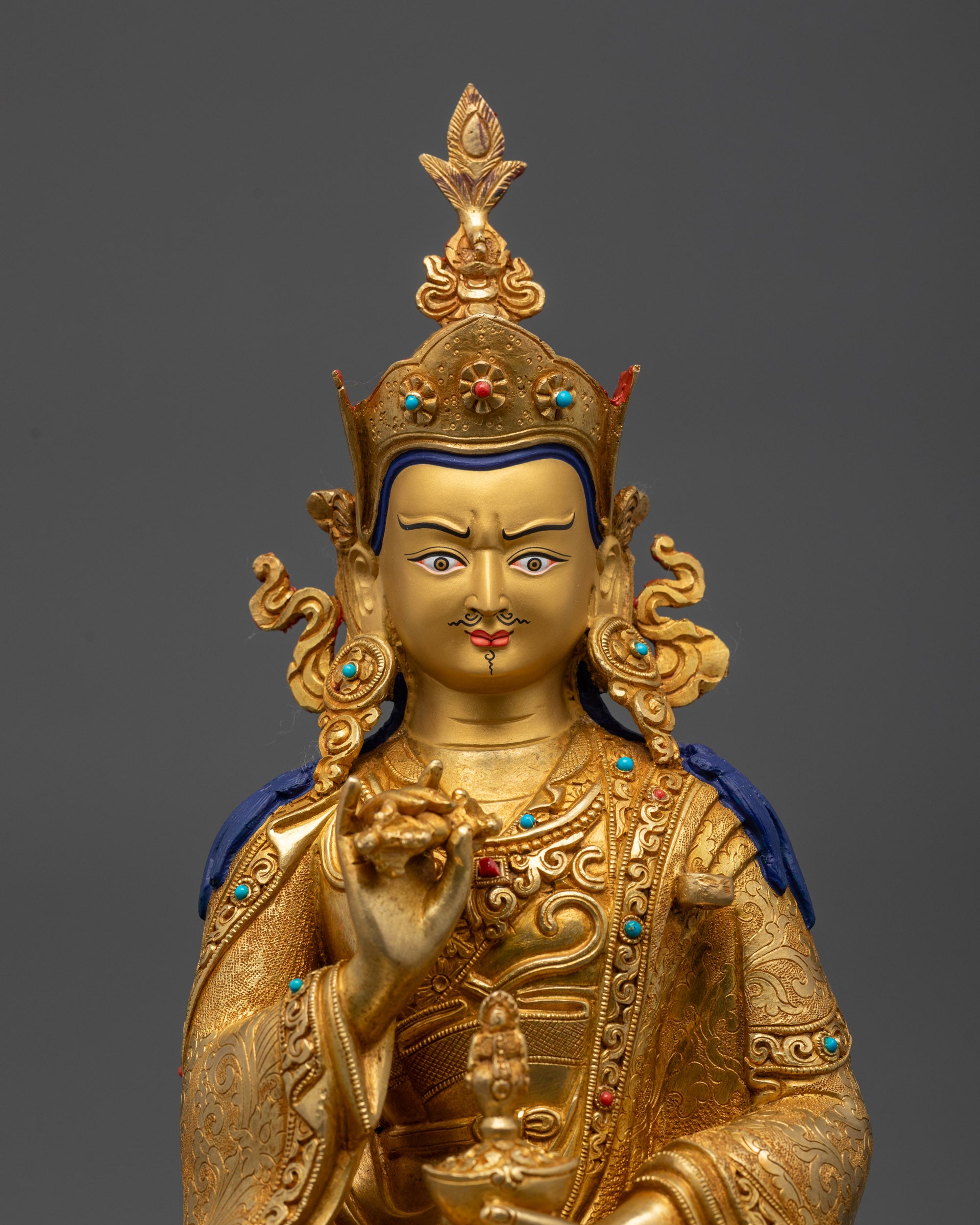 Close up of Tsokye Dorje holding vajra and skull cup with intricate hand-engraved robes
