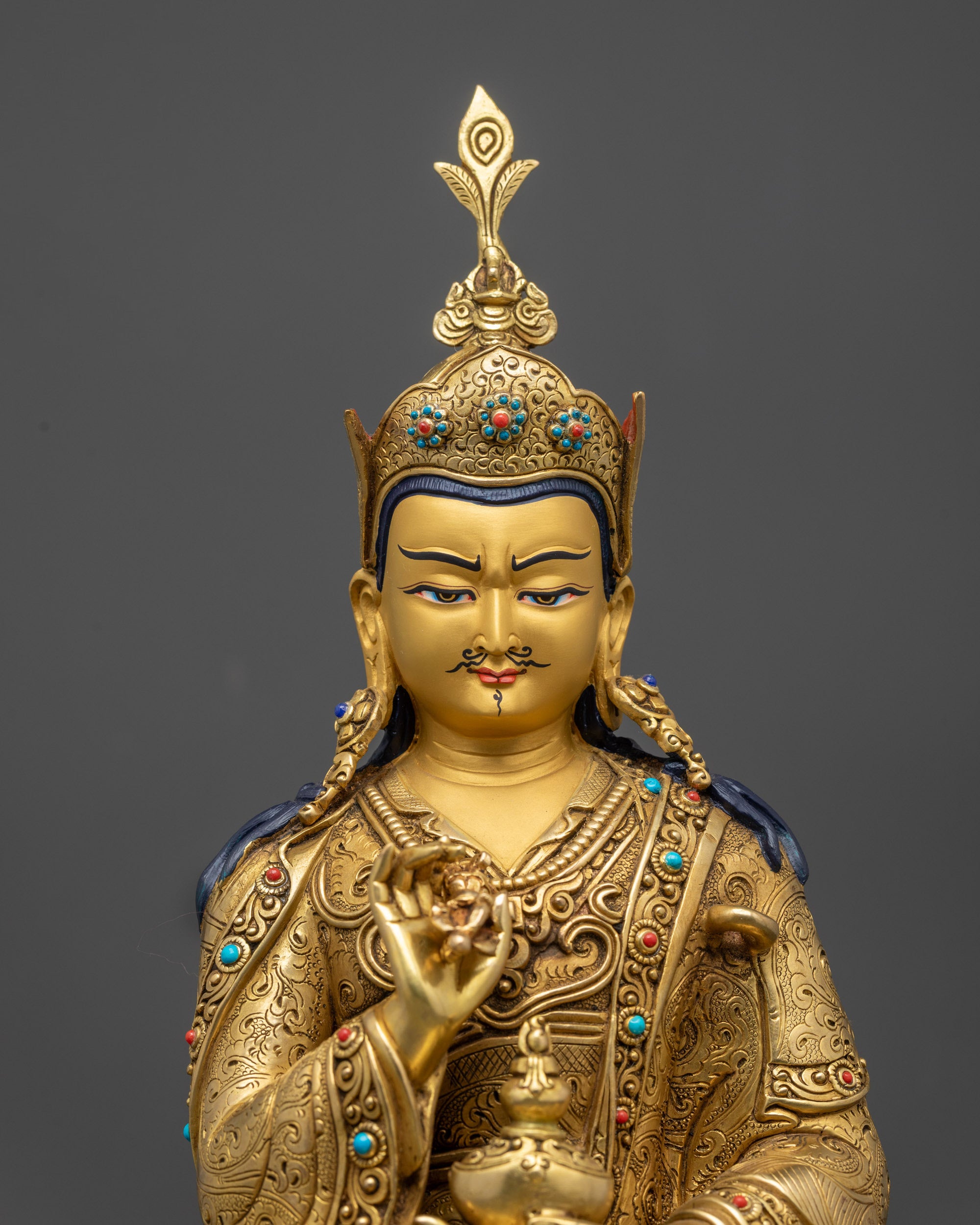 Close up of Tsokye Dorje semi-wrathful gold-gilded face with detailed robe
