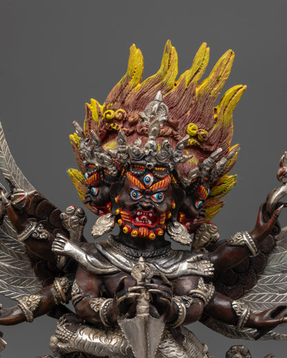 Close up of Vajrakilaya Statue showing three faces, six arms, and sacred objects