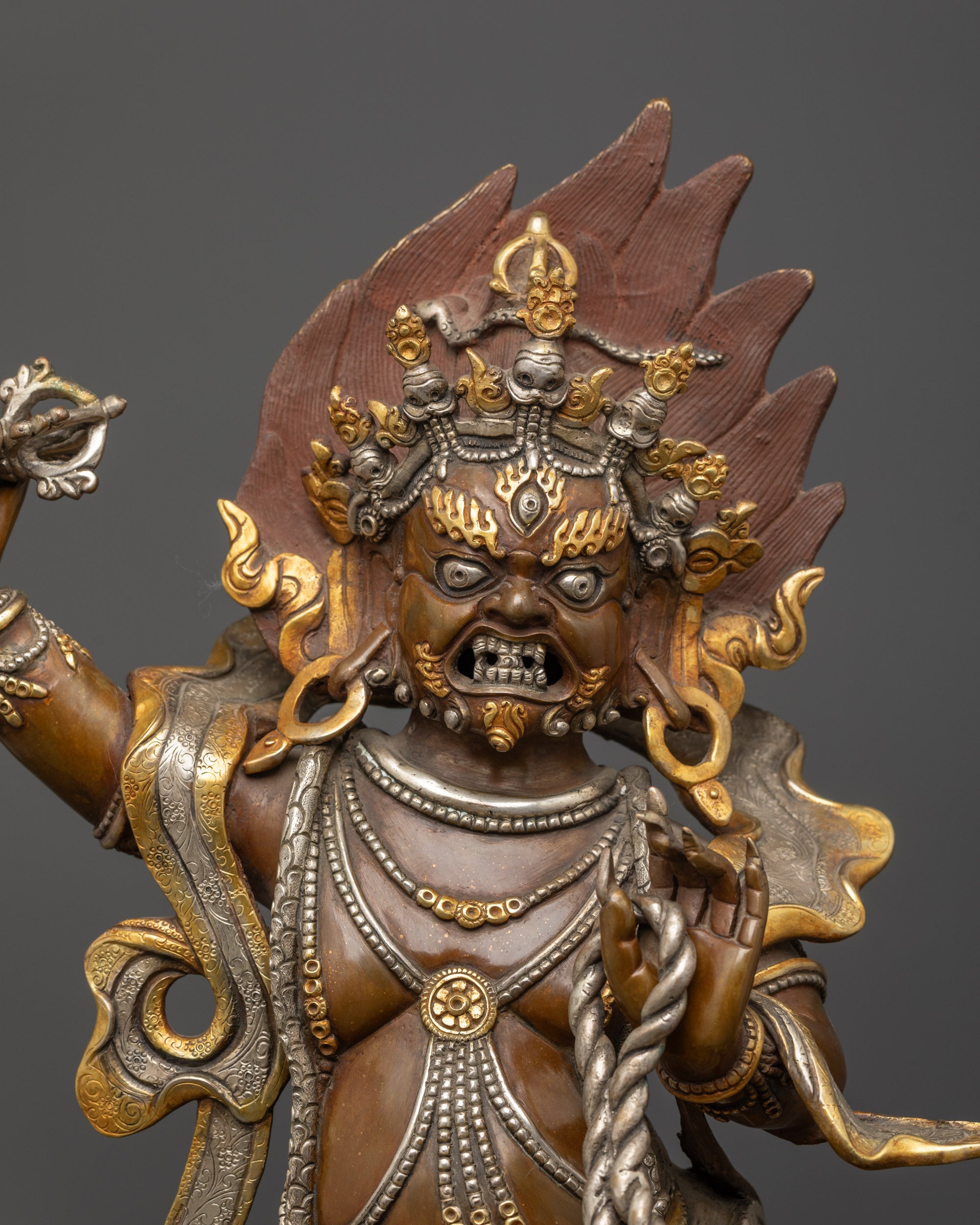 Close up of Vajrapani statue showing silver-plated Vajra, Lasso, and skull crown