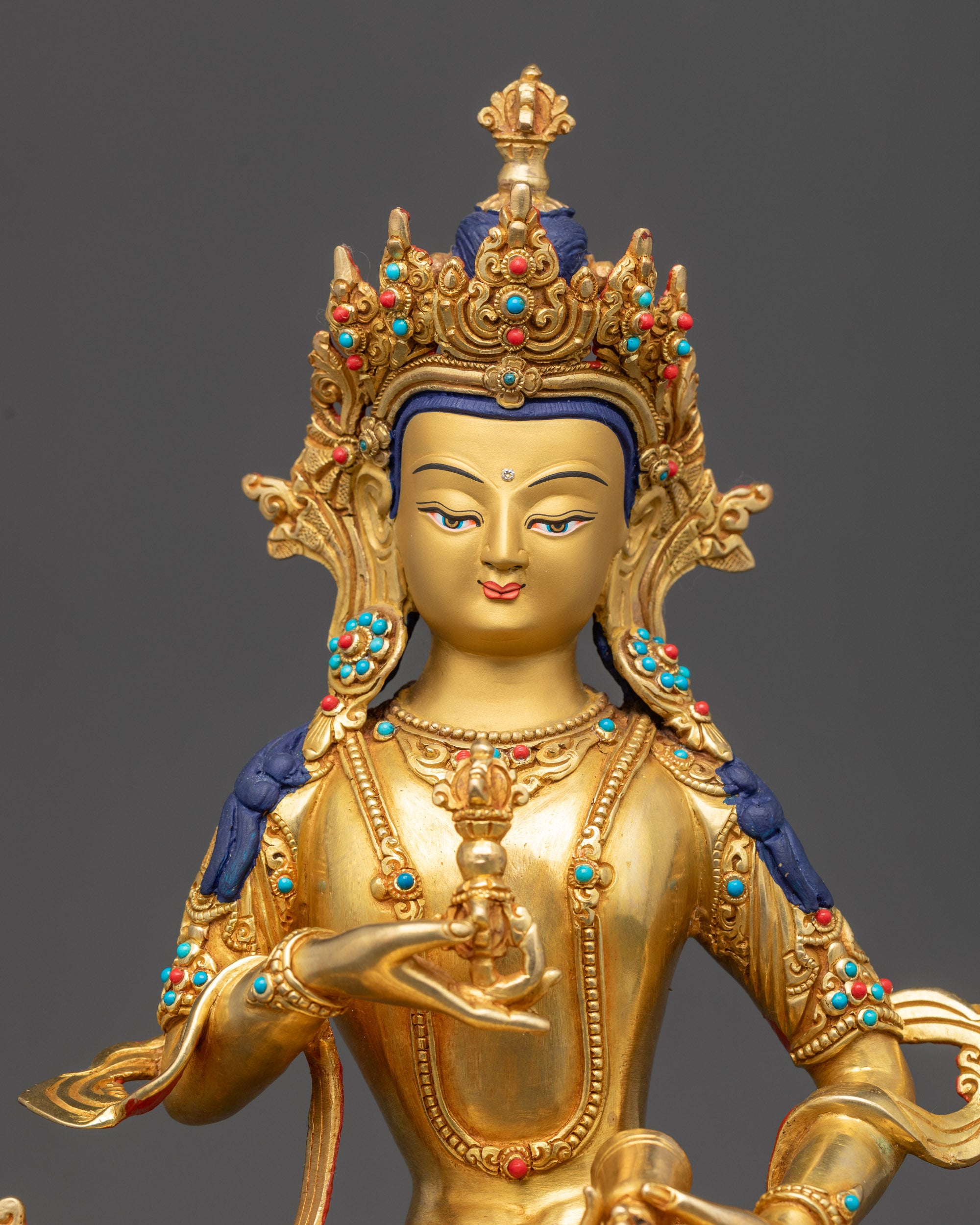 Close up of Vajrasattva Dorje Sempa face showing tranquil gaze and gold-gilded details
