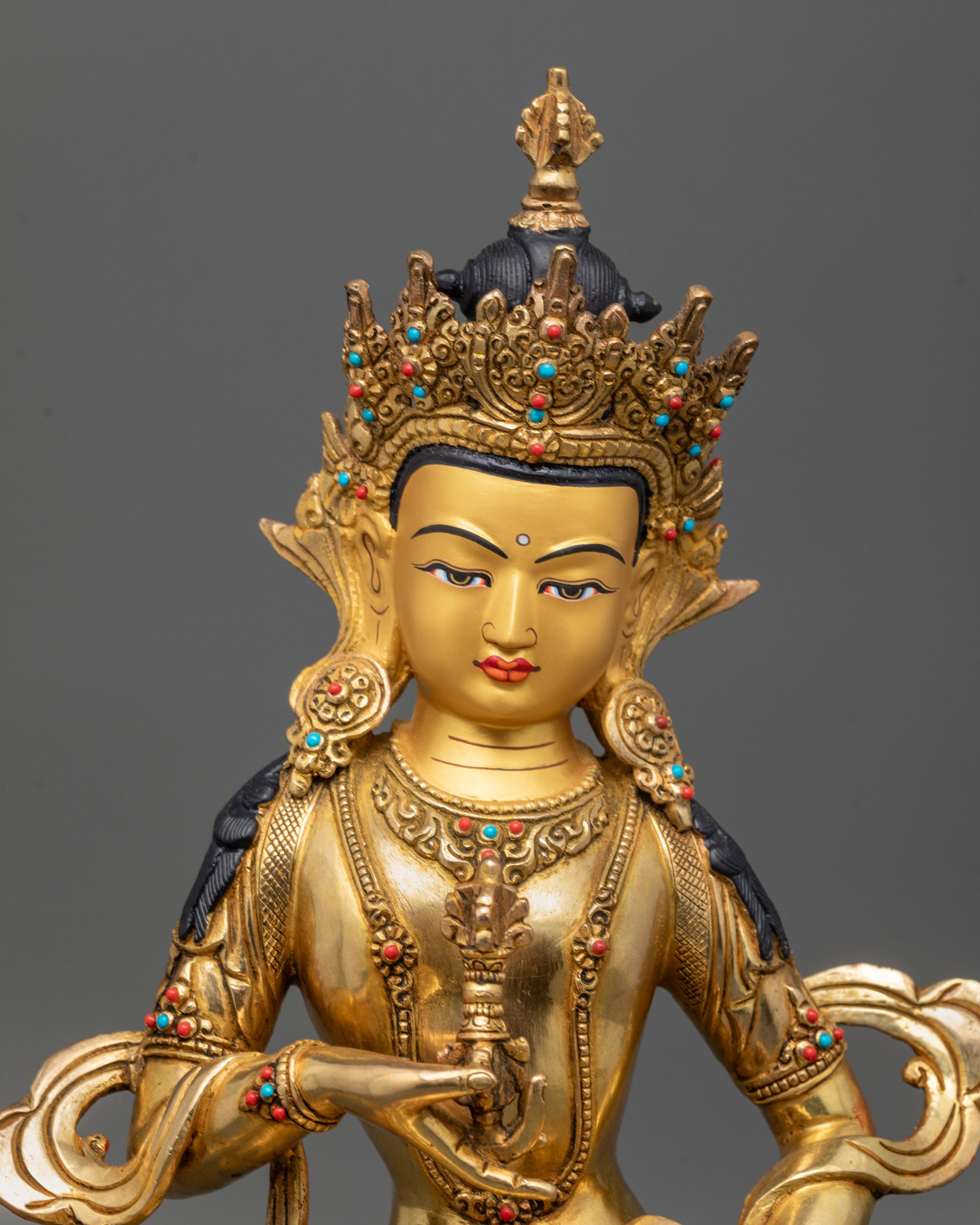 Close up of Vajrasattva Statue showing calm expression, Dorje, Ghanta, and jeweled crown