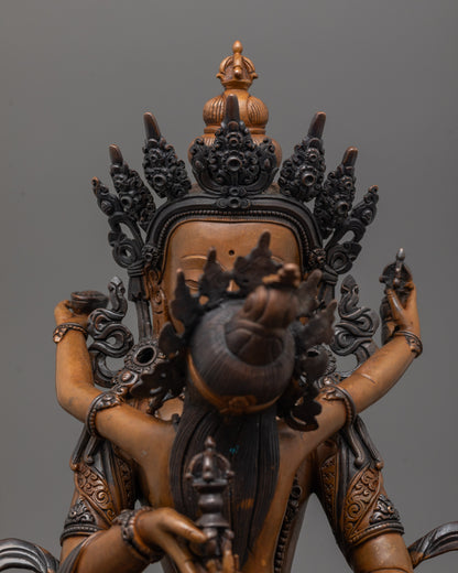 Close up of Vajrasattva’s vajra and bell in oxidized copper with rich patina finish
