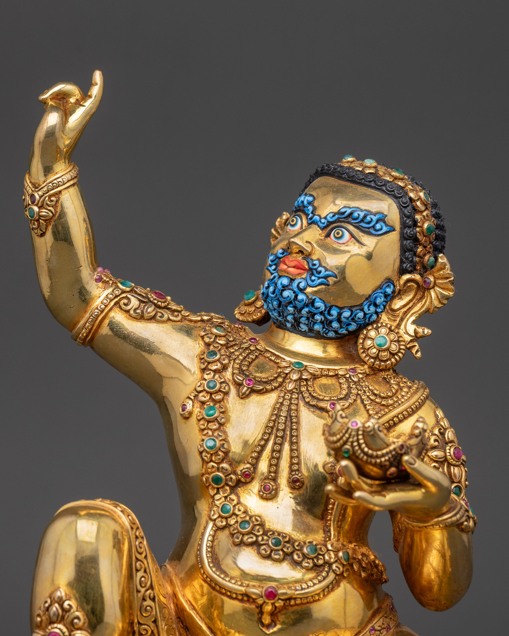 Close up of Virupa holding kapala with detailed carvings and gemstone jewelry