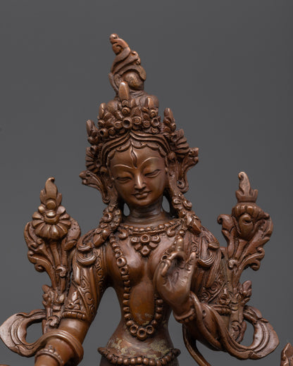 Close up of White Tara Statue showing compassionate face, seven eyes, and Utpala flower