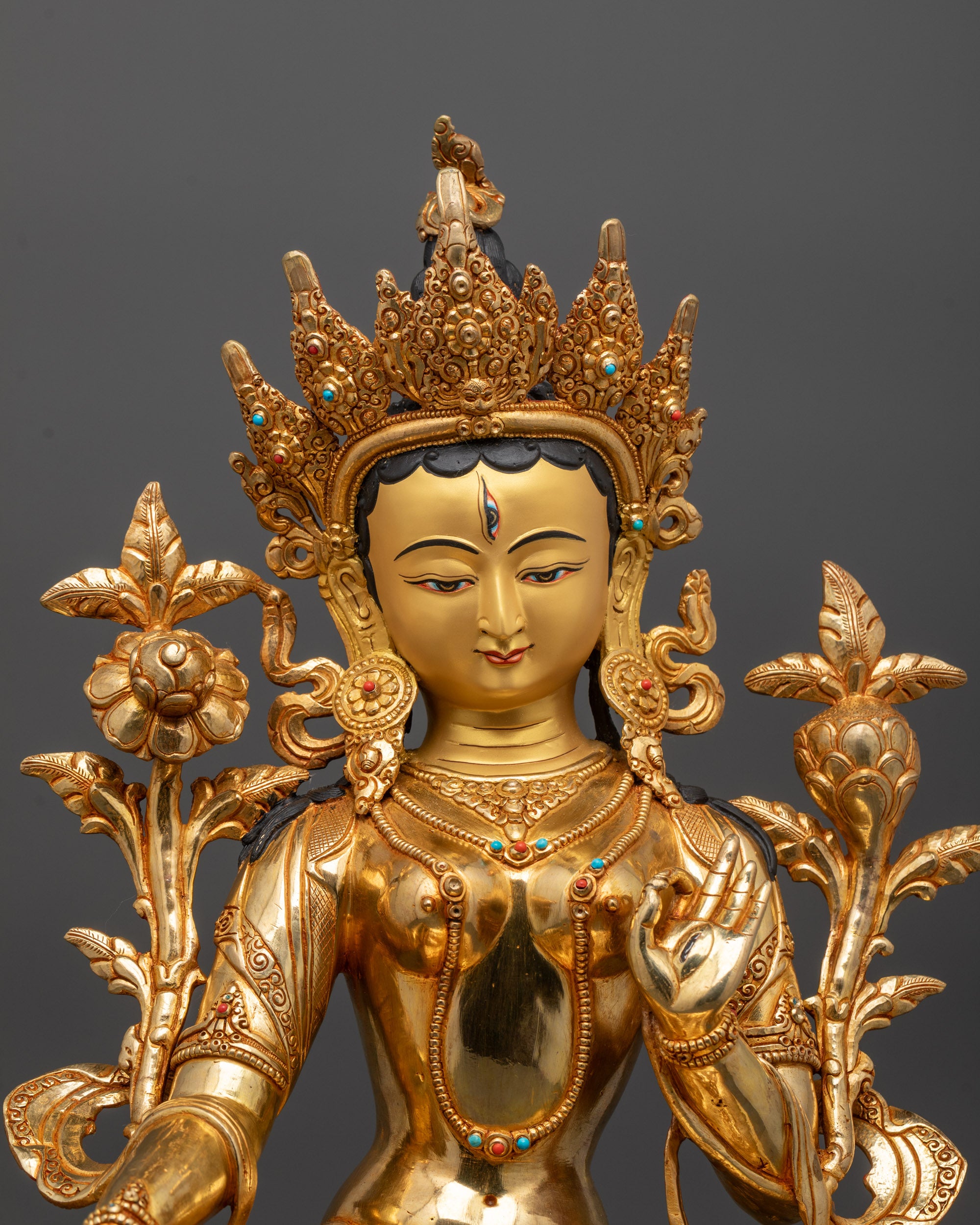 Close up of White Tara’s five-jeweled crown and semi-precious stones on flowing robe