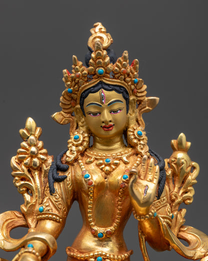 Close up of White Tara statue showing gold fire-gilding and semi-precious stones
