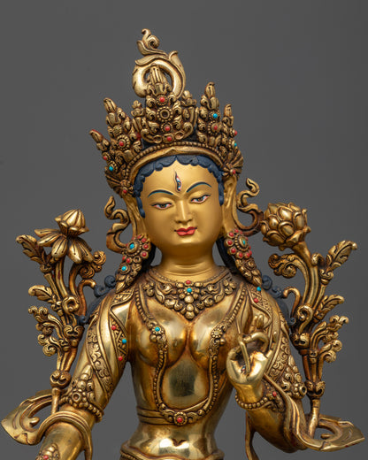 Close up of White Tara statue showing seven wisdom eyes and blue utpala flower
