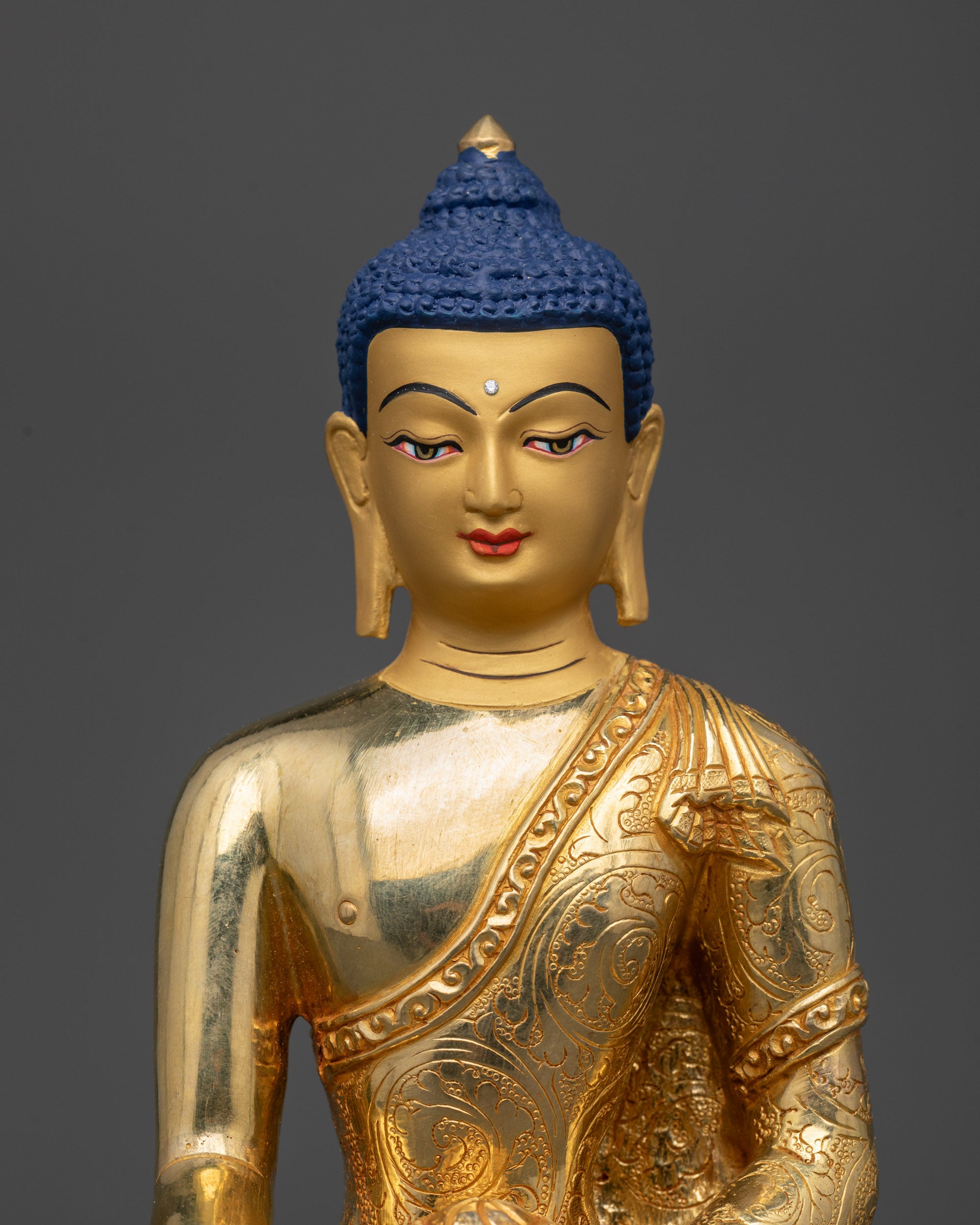 Close up of a hand-carved Shakyamuni Buddha statue on lotus seat.