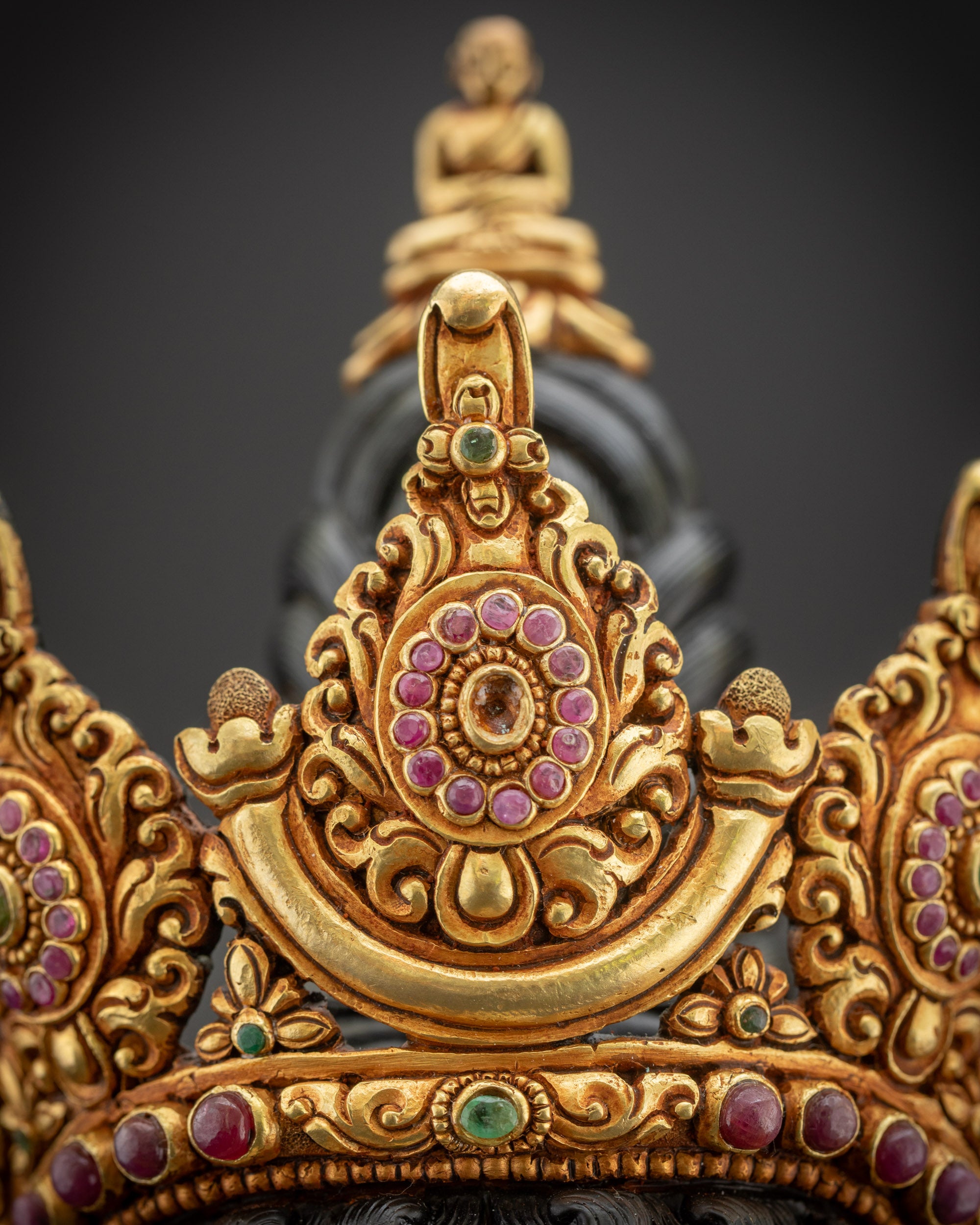 Close up of crown showing five-jewelled top with Buddha figure