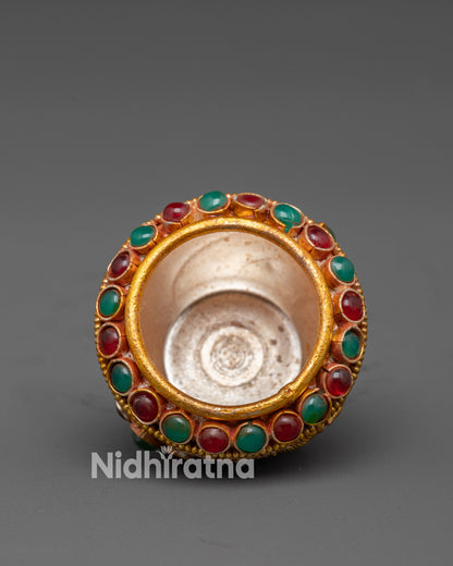 Close up of deity figure and semi-precious stones on Tibetan Golpa bowl