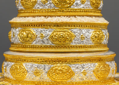 Close up of gold-plated auspicious symbols on four rings of Tibetan Mandala