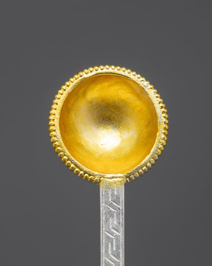 Close up of gold-plated scooping bowl on Tibetan ritual spoon
