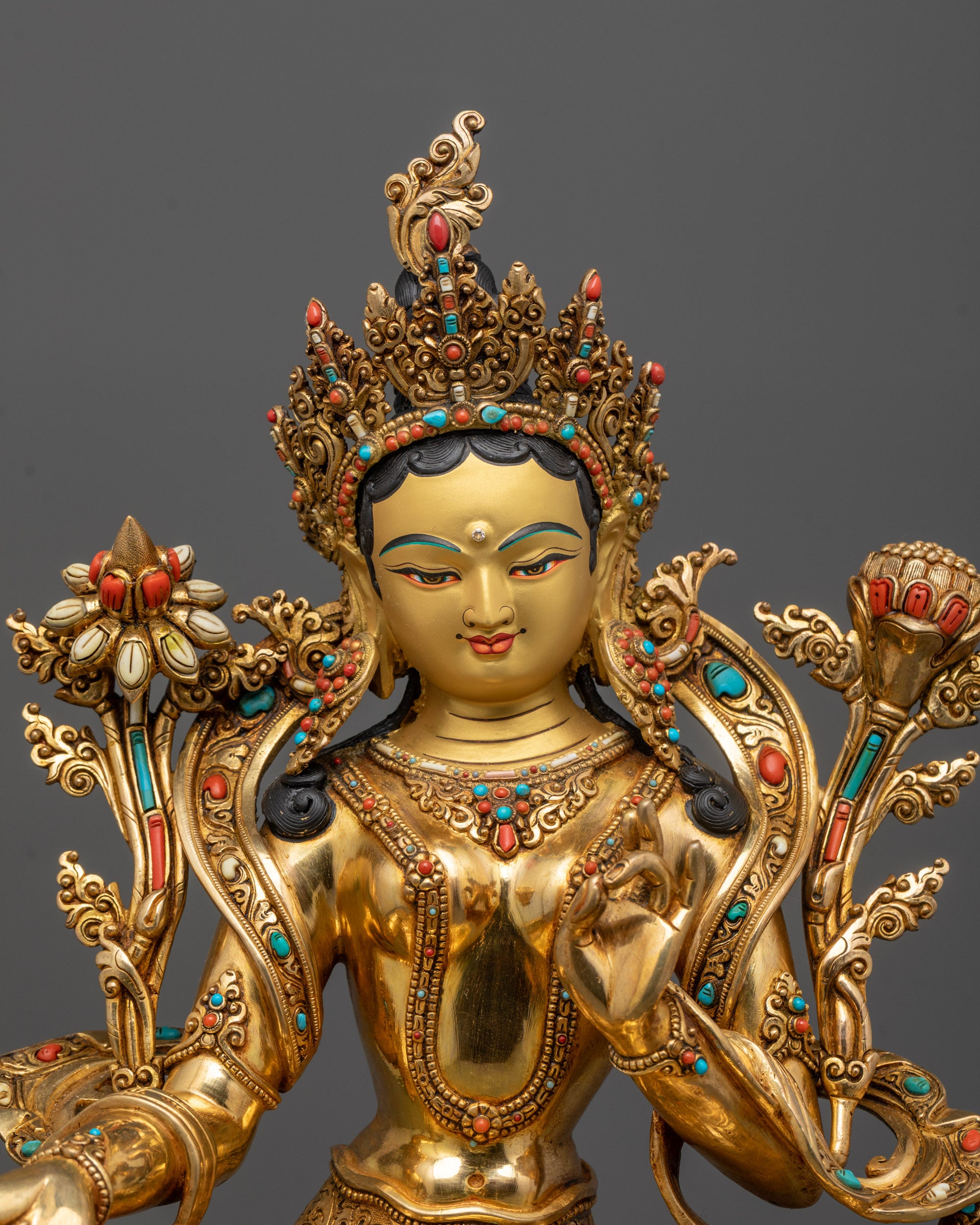 Close up of hand-carved details and semi-precious stones on Green Tara’s flowing robes