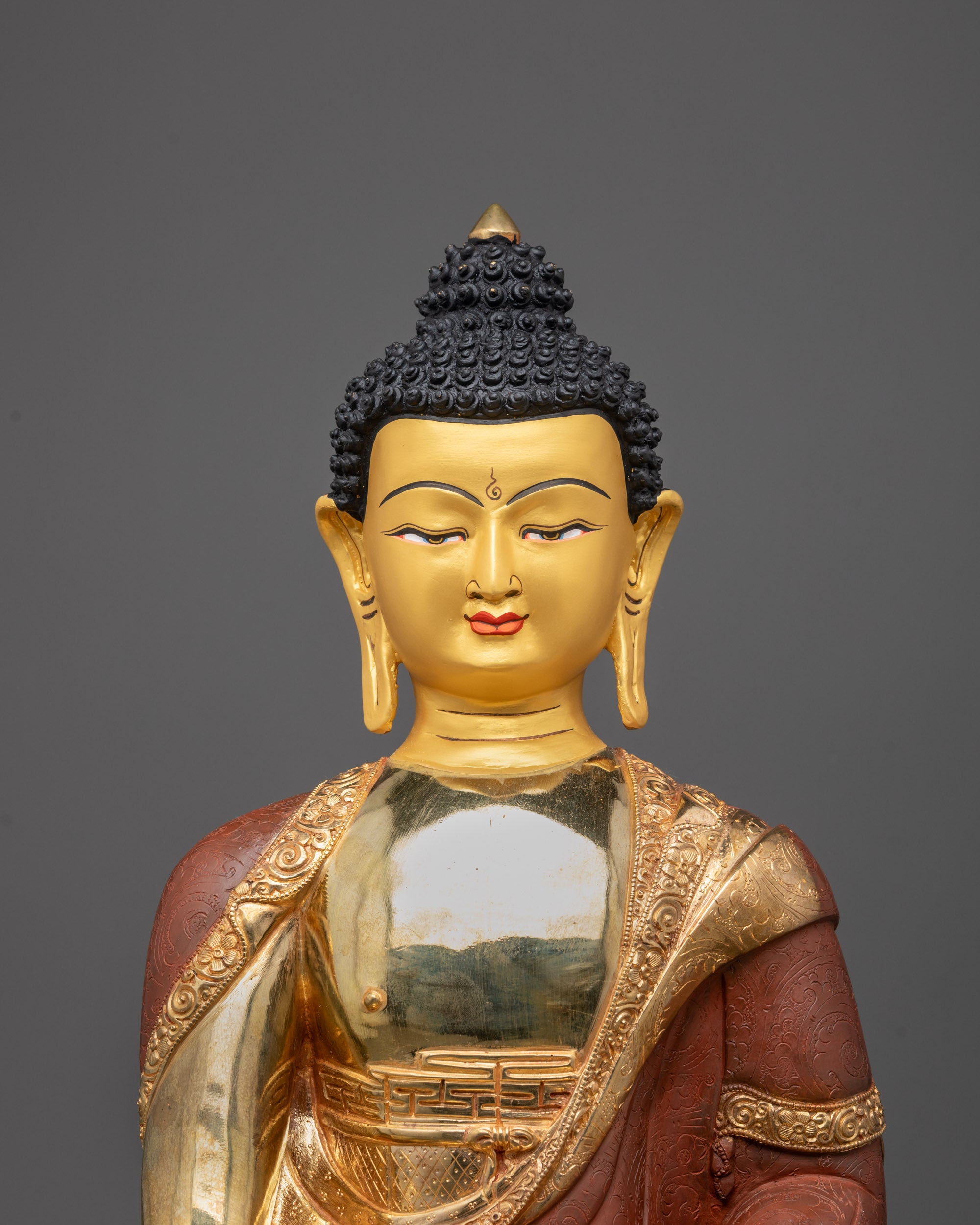 Close up of hand-carved monk’s robe patterns and gold fire-gilding on Buddha statue