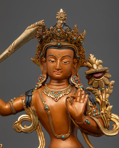 Close up of hand-painted orange-hued Manjushri sculpture from Nepalese artisans
